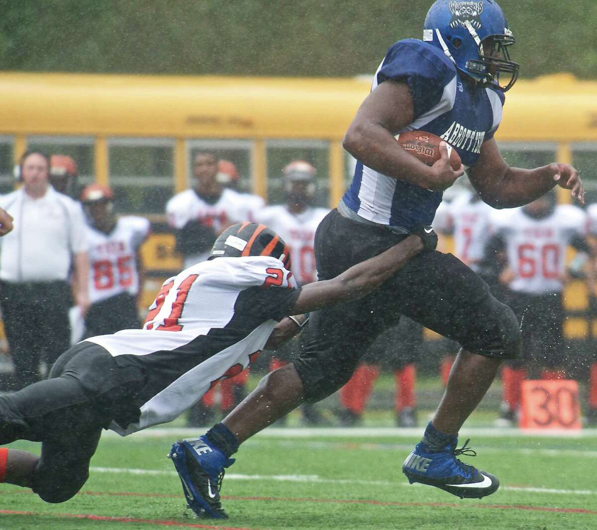 FILE PHOTO: Bullard-Havens Hakeem Fletcher, 21, is dragged downfield as he tries to tackle Abbott Tech's Delton Rogers, 35, during a High School football game between Bullard-Havens Tech and Abbott Tech High School's at Perry Memorial Field in Rogers Park, Danbury, Conn, Saturday, September 21, 2013.