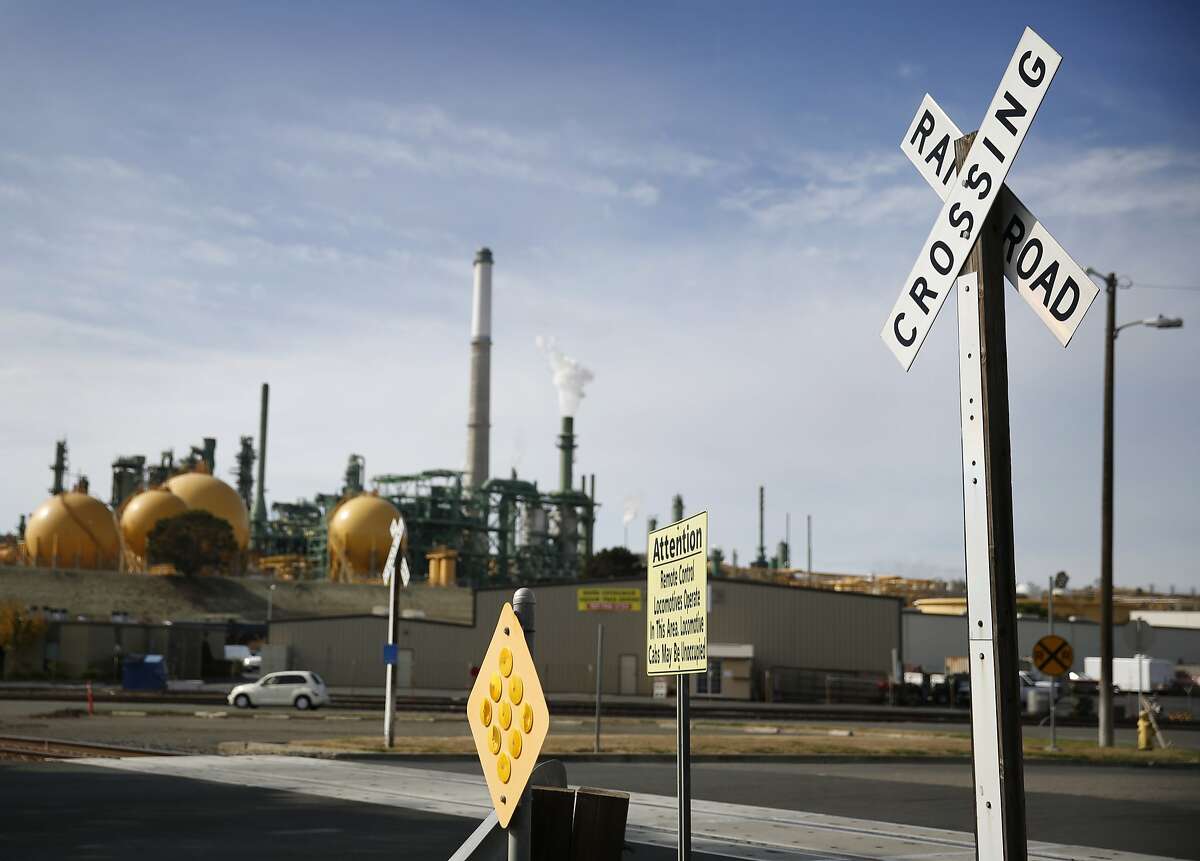 The Valero refinery is seen in the background behind signage for a railroad crossing on Wednesday, October 22, 2014 in Benicia, Calif.