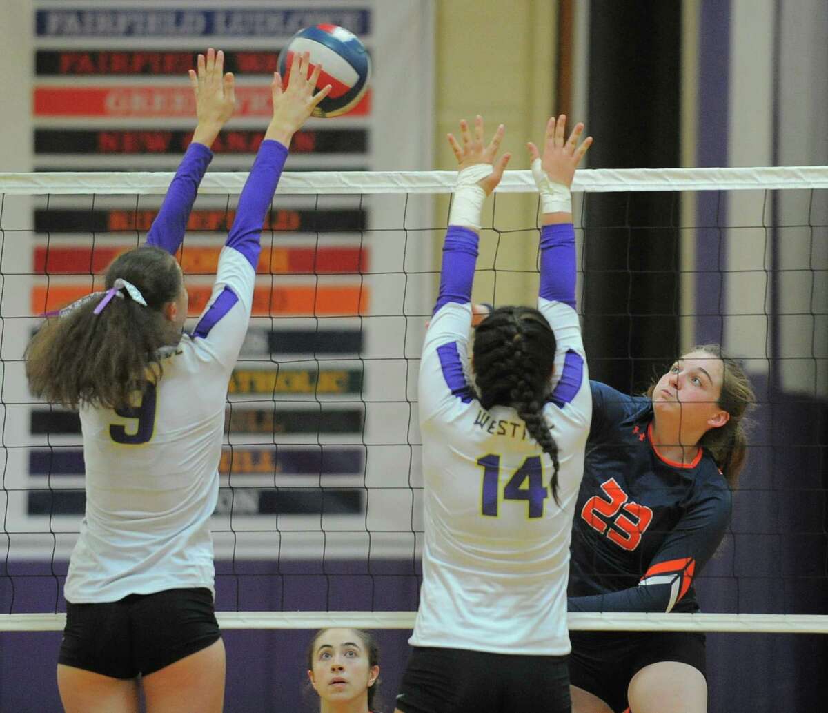 Danbury Emily Broggy puts the ball past WesthillBetsy Sachs and Courtney Xu during an FCIAC conference volleyball match at Westhill High School in Stamford, Conn. on Wednesday, Sept.21, 2016.