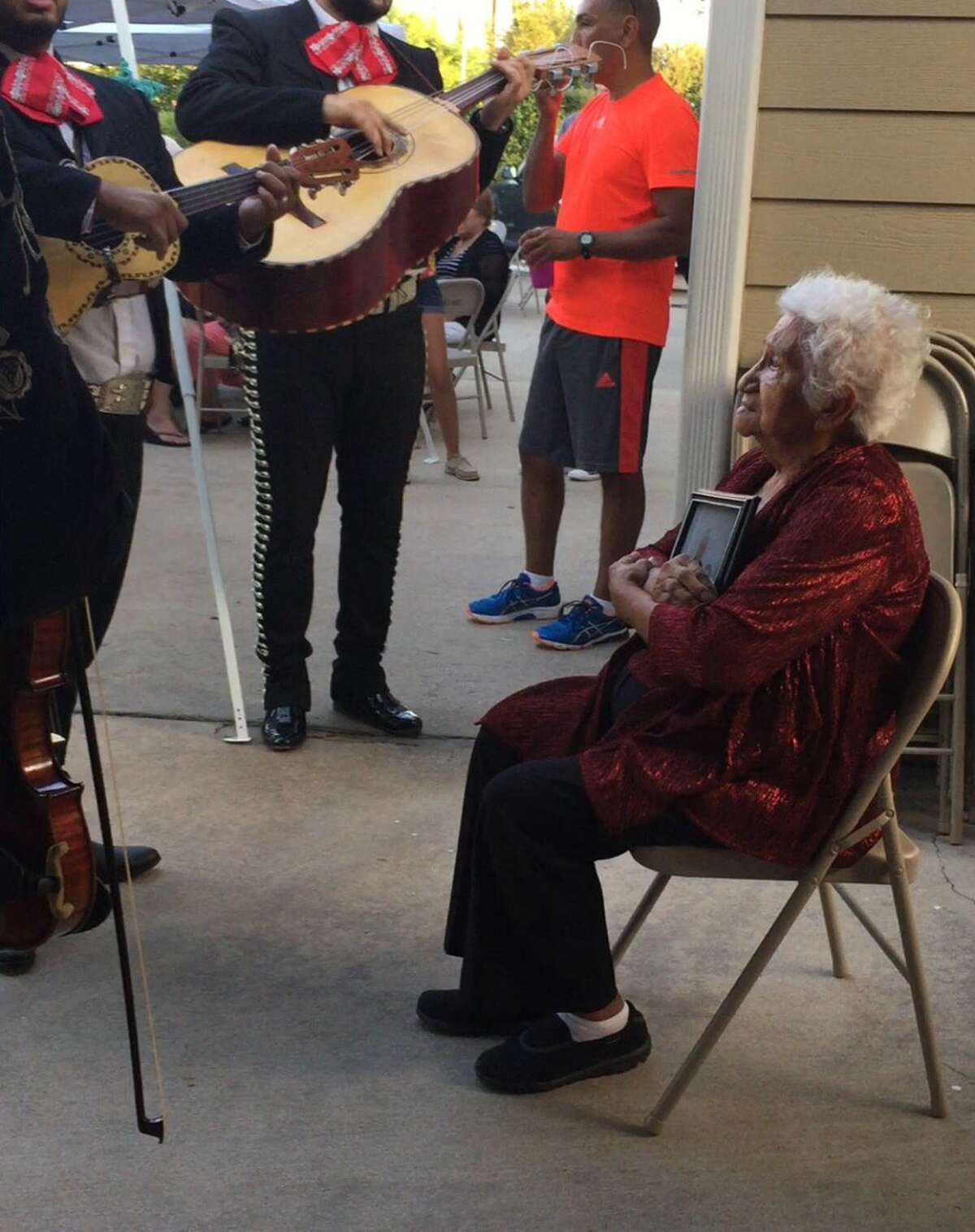 Josie Reza, 85, enjoying her mariachi serenade while holding a photo of her late husband on Sept. 17, 2016. 