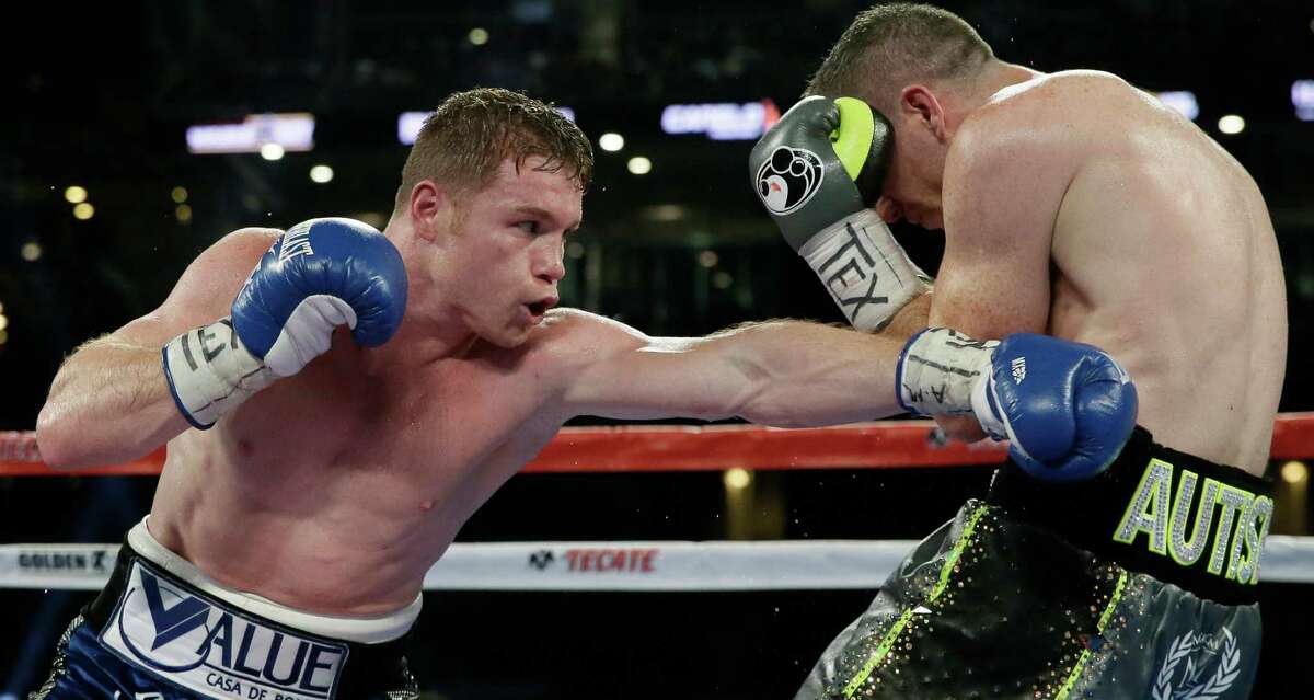 Canelo Alvarez (left) punches Liam Smith fight during the WBO junior middleweight championship boxing match at AT&T Stadium in Arlington on Sept. 17, 2016.