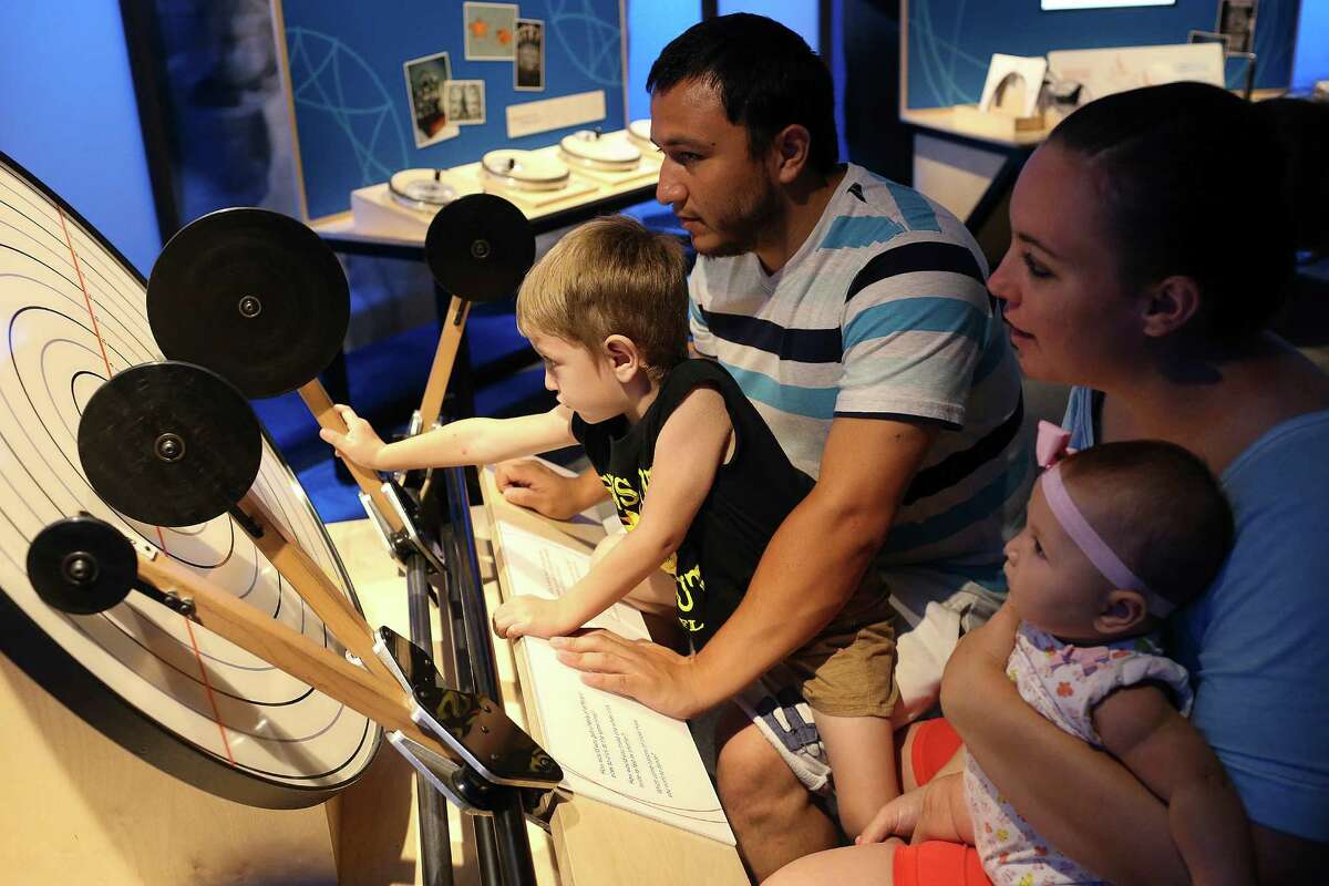 Liam Reyes, 3, plays with a game that explores frequencies at the Mathletics exhibit at the DoSeum on Aug. 28. The exhibit lets the public explore fundamental math concepts. With Reyes are from left, his father, Luis Reyes, 27, mother, Rebeka Reyes, 24 and sister, Spencer, 5-month-old. The family was on vacation from San Angelo.
