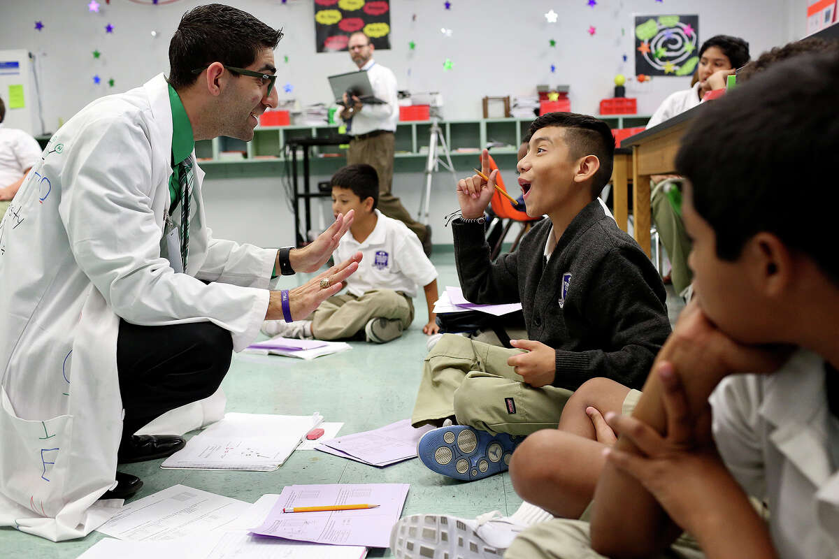 Science teacher JB Maldonado, left, talks with 6th grader Michael Pike during their class at the Young Men’s Leadership Academy in the SAISD on Sept. 22, 2015. Maldonado was attracted to the school's principles of character, discipline and leadership.