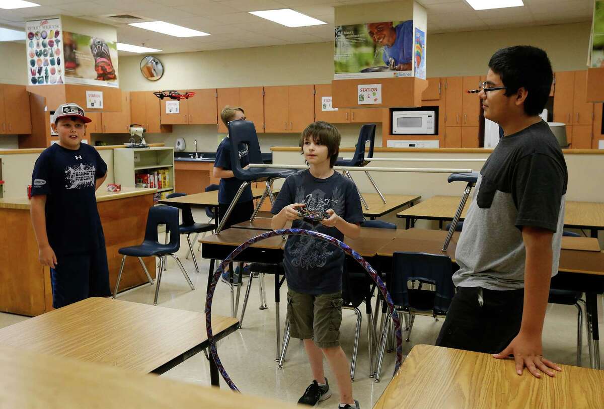 Eirik Marquez (from left), Connor Mellor and Brandon Ochoa keep an eye on their drone as 18 NEISD middle and high school students attend Drone Camp where students build and program their own drones. On Thursday, July 28, 2016, the last day of camp, students flew their drones through a makeshift obstacle course at Roosevelt High School. The students consisted of middle and high school NEISD students. Many attend Ed White Middle School and Roosevelt High School's magnet programs: Design and Technology Academy (DATA) and Engineering and Technology Academy (ETA).