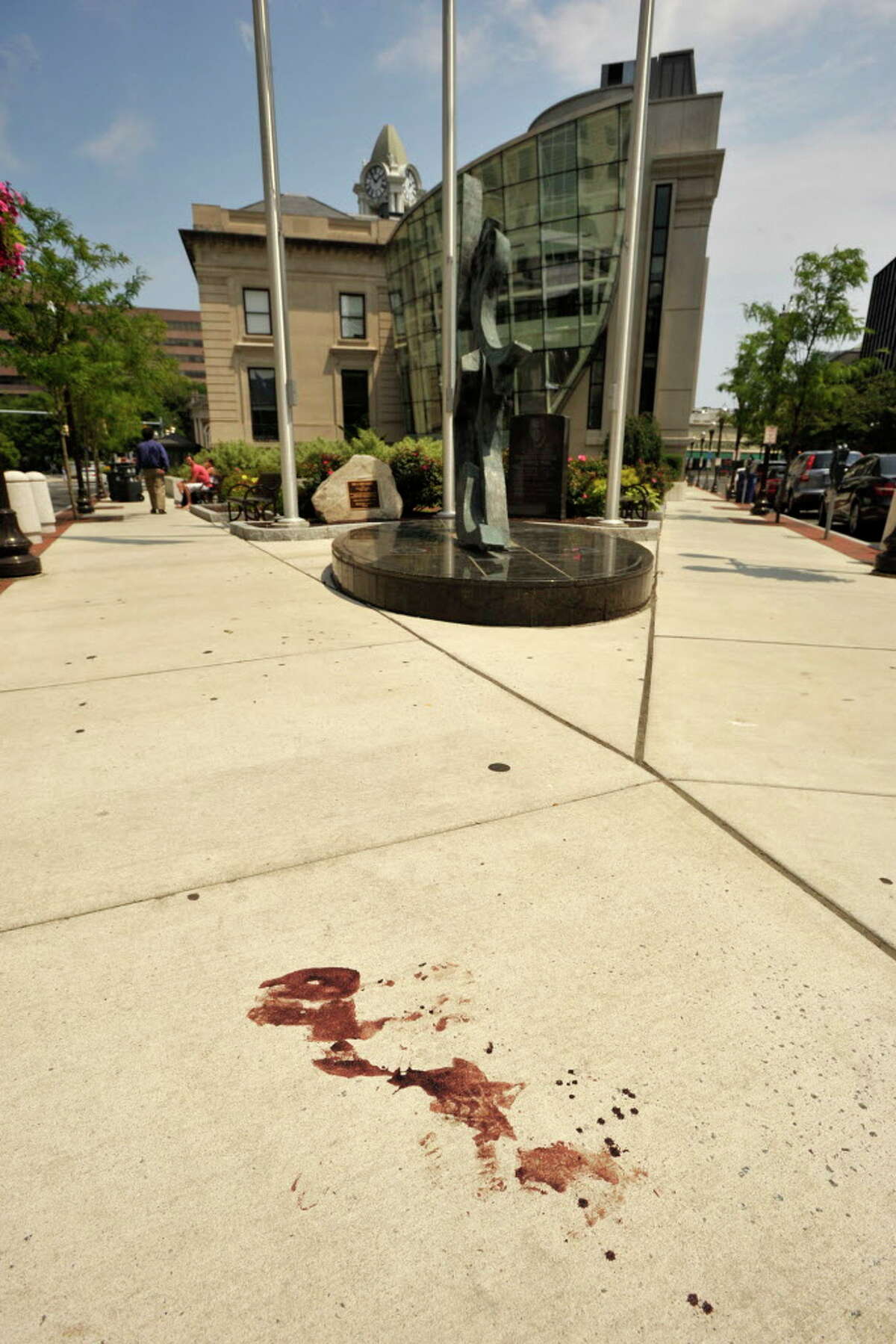 FILE — The sidewalk at the corner of Main and Bank Streets where a witness said he saw a victim retreat to after being shot in Stamford, Conn., on Sunday, July 13, 2014. In the early morning hours of Sunday police say Dayron Wills opened fire with a handgun outside a Columbus Park night club striking five people. The five victims were said to not have life-threatening injuries.