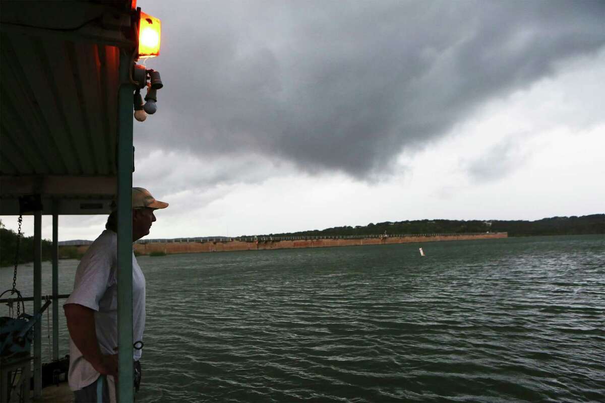 Mike Crandall of Wallys Water Sports peers across Medina Lake as a storm rolls into the area on May 31.
