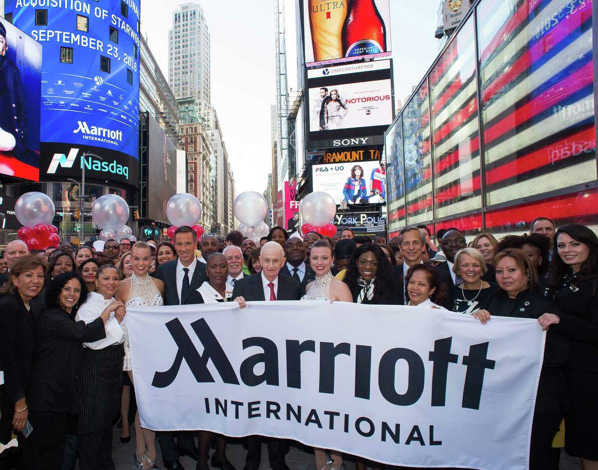 Bill Marriott (center left), executive chairman of Marriott International, and Arne Sorenson (fifth from left), CEO and president, join with the Marriott executive team and associates in Times Square to celebrate the company's acquisition of Starwood on Friday.