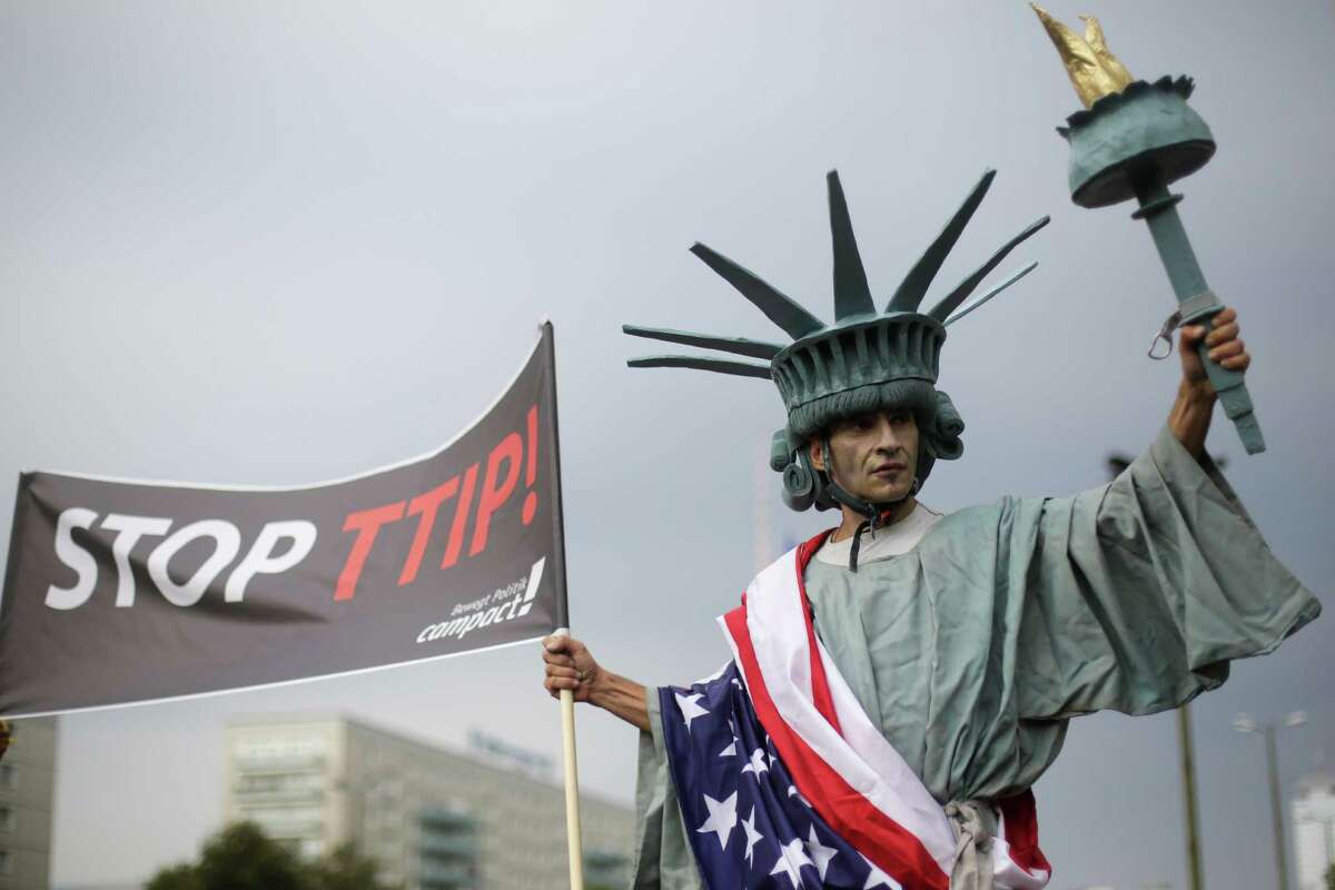 A man dressed like the Statue of Liberty attends a demonstration against the planned Transatlantic Trade and Investment Partnership, TTIP. Opponents in Europe argue that the trade deal would water down EU standards. For example, European consumer groups worry that food in the U.S. is not produced to the same health and environmental standards as in Europe.