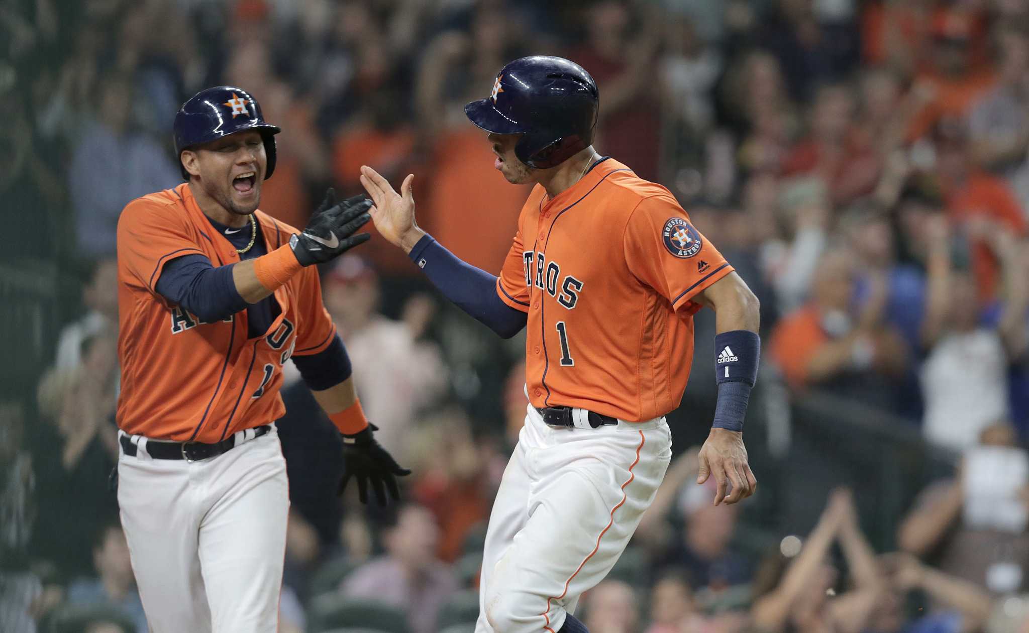 Houston Astros' George Springer (4) celebrates with catcher Evan Gattis  (11) after beating the Los Angeles