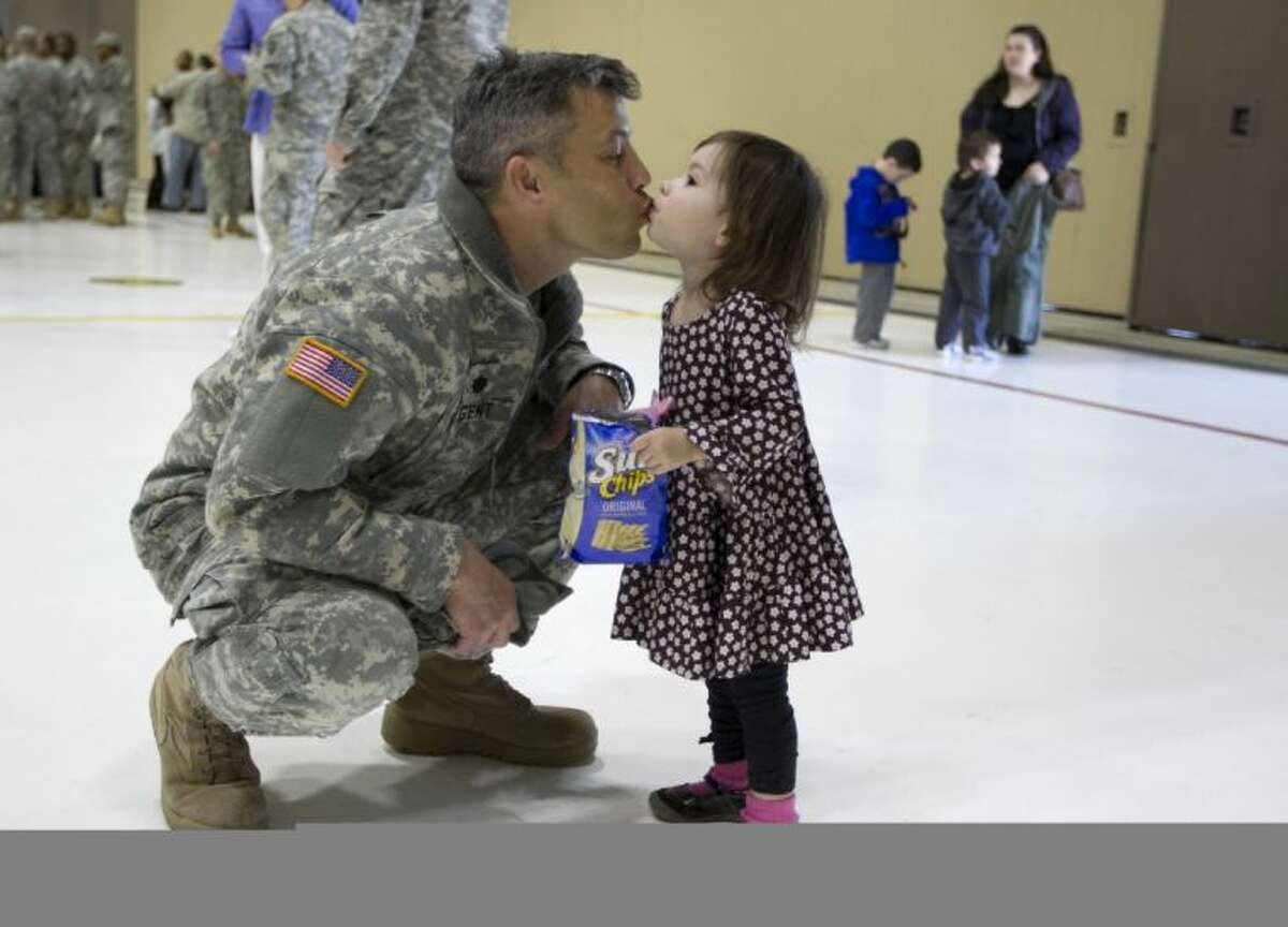 Lt. Col. Jim Nugent of the Texas Army National Guard 36th Infantry Division kisses his daughter, Sienna Nugent, 23 months old, after a deployment ceremony at the Austin Army Aviation Support Facility in Austin on Wednesday.