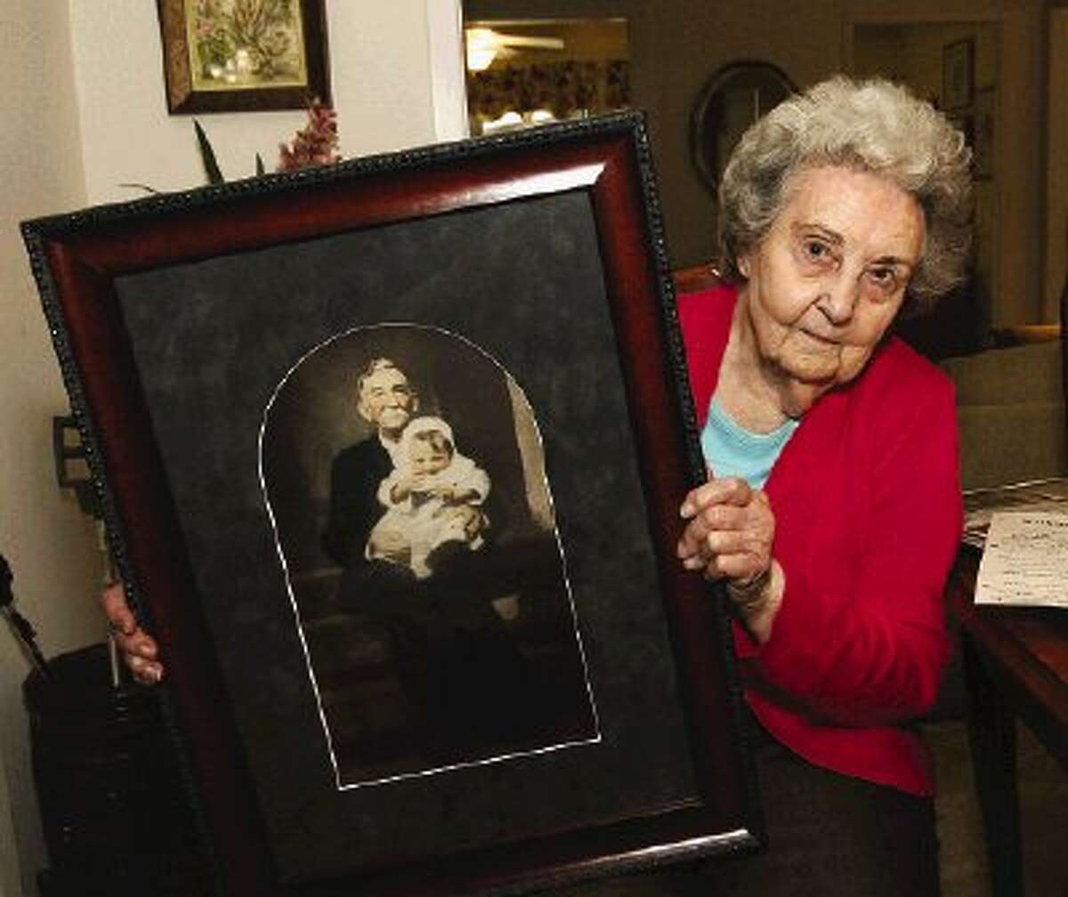 Floye Goodspeed displays a photo of herself sitting on the lap of her father, who was 75 when she was born.