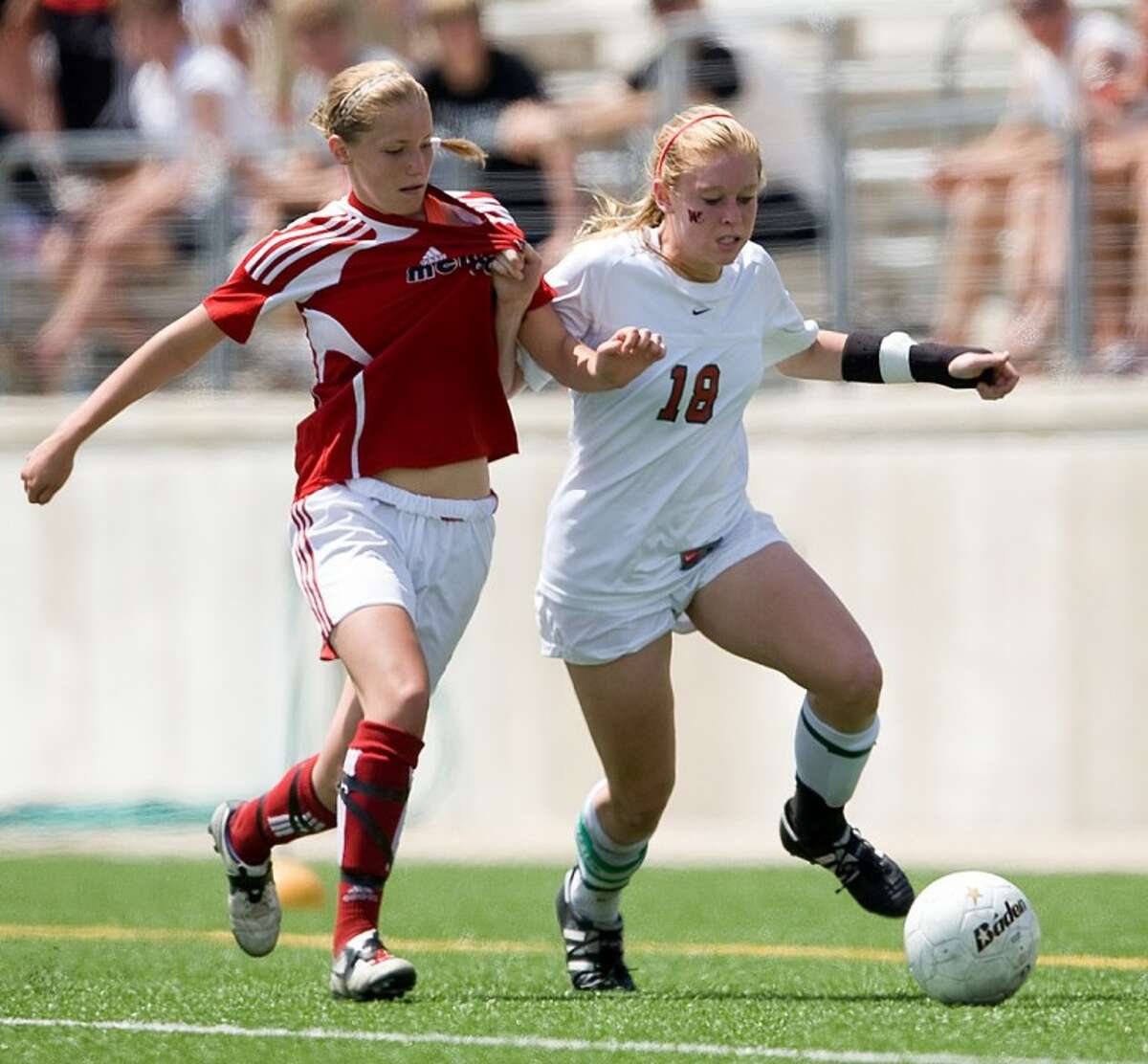 The Woodlands senior Natalie Kintigh fights off a McKinney Boyd defender during the Lady Broncos’ 1-0 win on Saturday in the Region II-5A final at the Kelly Reeves Athletic Complex in Austin.