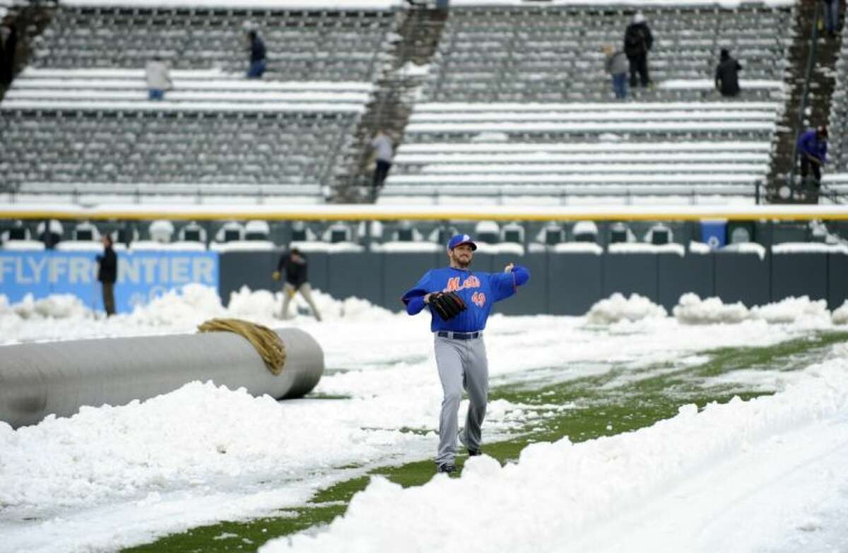 New York Mets pitcher Jonathon Niese throws in the snow before the start of a doubleheader between the New York Mets and Colorado Rockies on Tuesday in Denver.