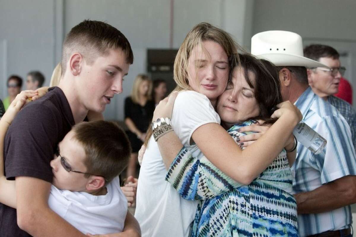 Mother Cindy Easterling, right, and sister Layne Wilson, along with brother Curtis Wilson and nephew Jaydon Wilson, embrace after the arrival of the body of Marine Sgt. Wade D. Wilson, 22, of Leon County, Friday at the Lone Star Executive Airport in Conroe. Wilson died May 11 while conducting combat operations in Helmand province, Afghanistan. See more photos online at yourhoustonnews.mycapture.com.