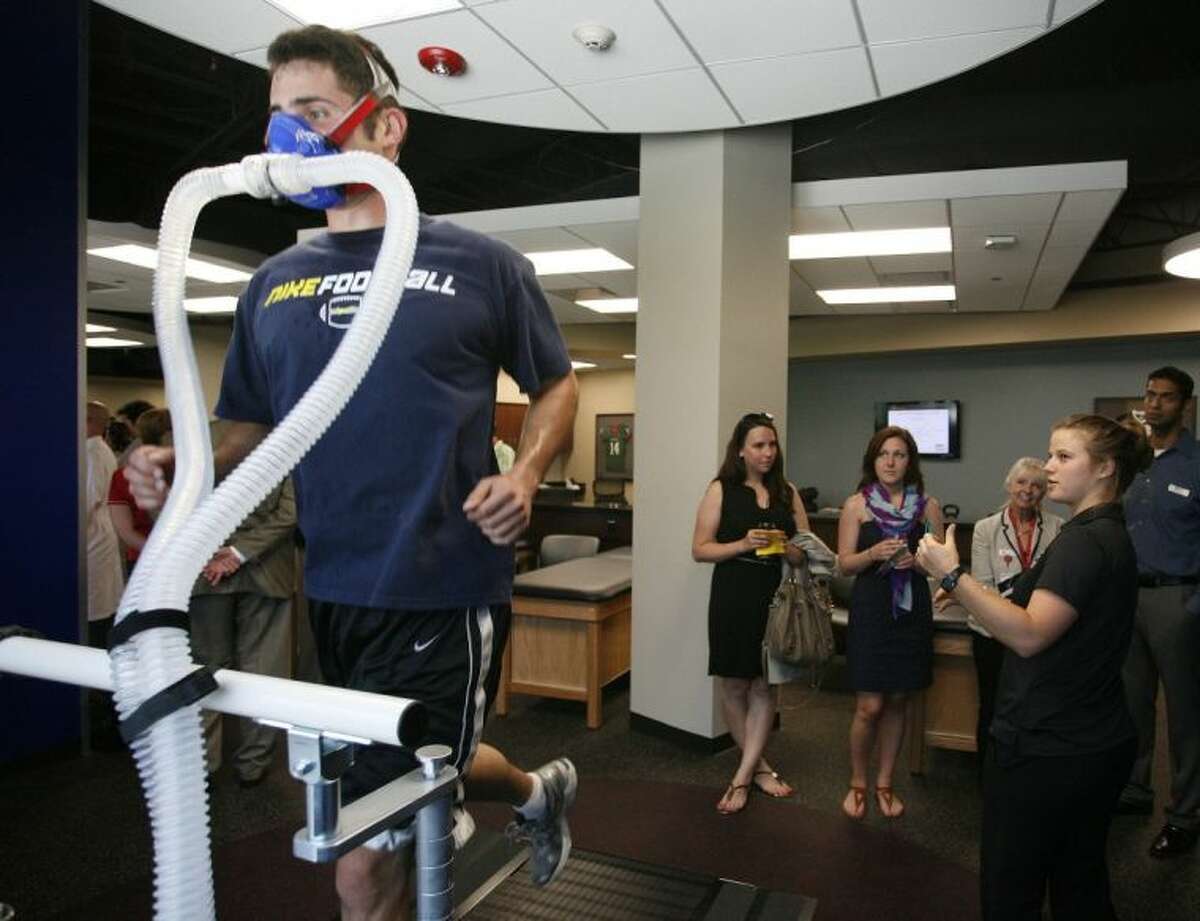A runner demonstrates the use of some of the specialized equipment available at the Memorial Hermann Ironman Sports Medicine Institute in The Woodlands, as Exercise Physiologist Allison Shepherd, right, explains to visitors the benefits of such equipment.