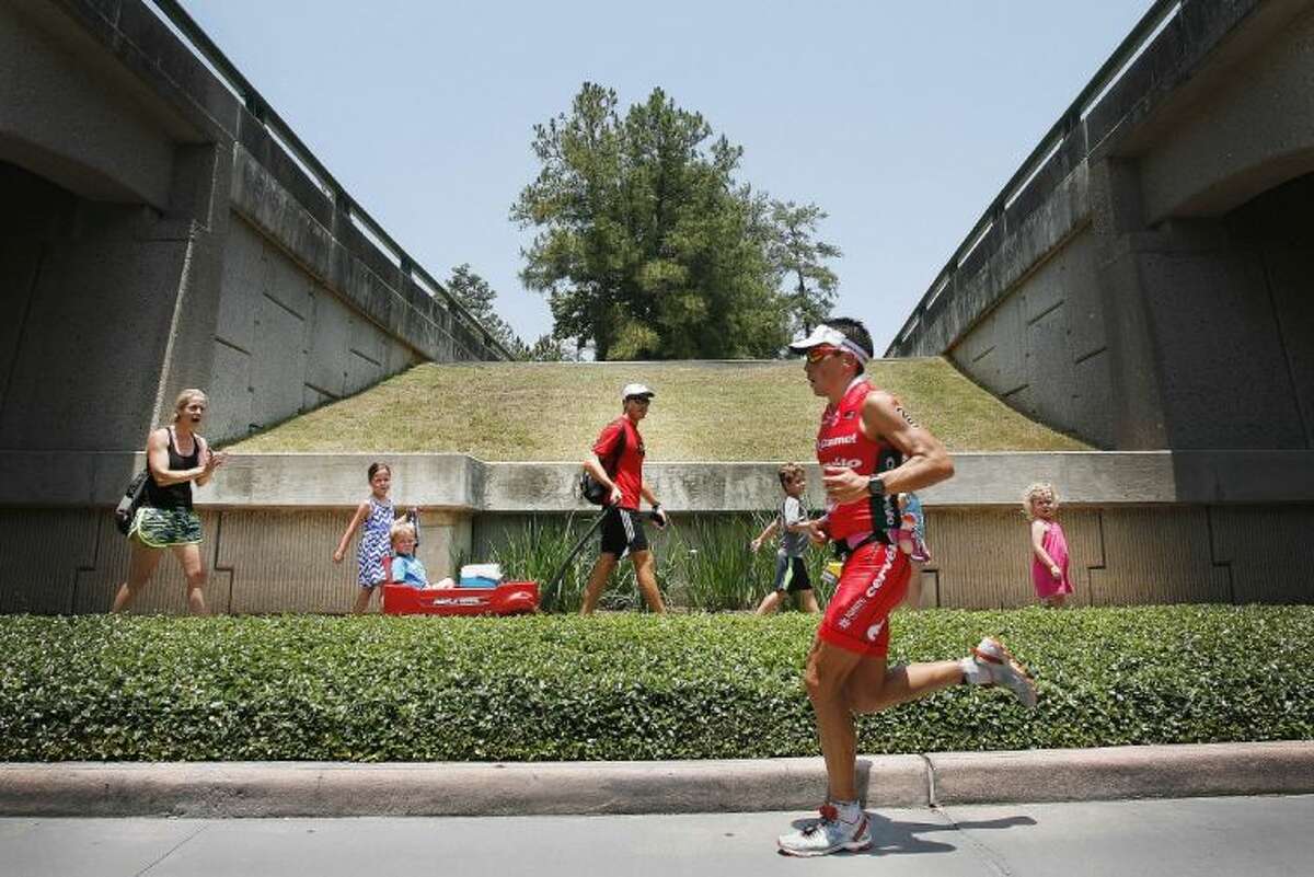 Triathlete Andres Castillo LaTorre runs past spectators during Saturday’s 2013 Ironman Texas triathlon in The Woodlands. To view or order this photo and others like it, visit: HCNPics.com.