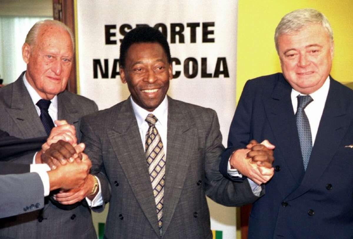 Former Brazilian soccer player Pelé, center, joins hands with former FIFA President Joao Havelange, left, and Ricardo Teixeira, president of the Brazilian Soccer Confederation, during a 2001 meeting to clean up Brazilian soccer in Brasilia, Brazil.