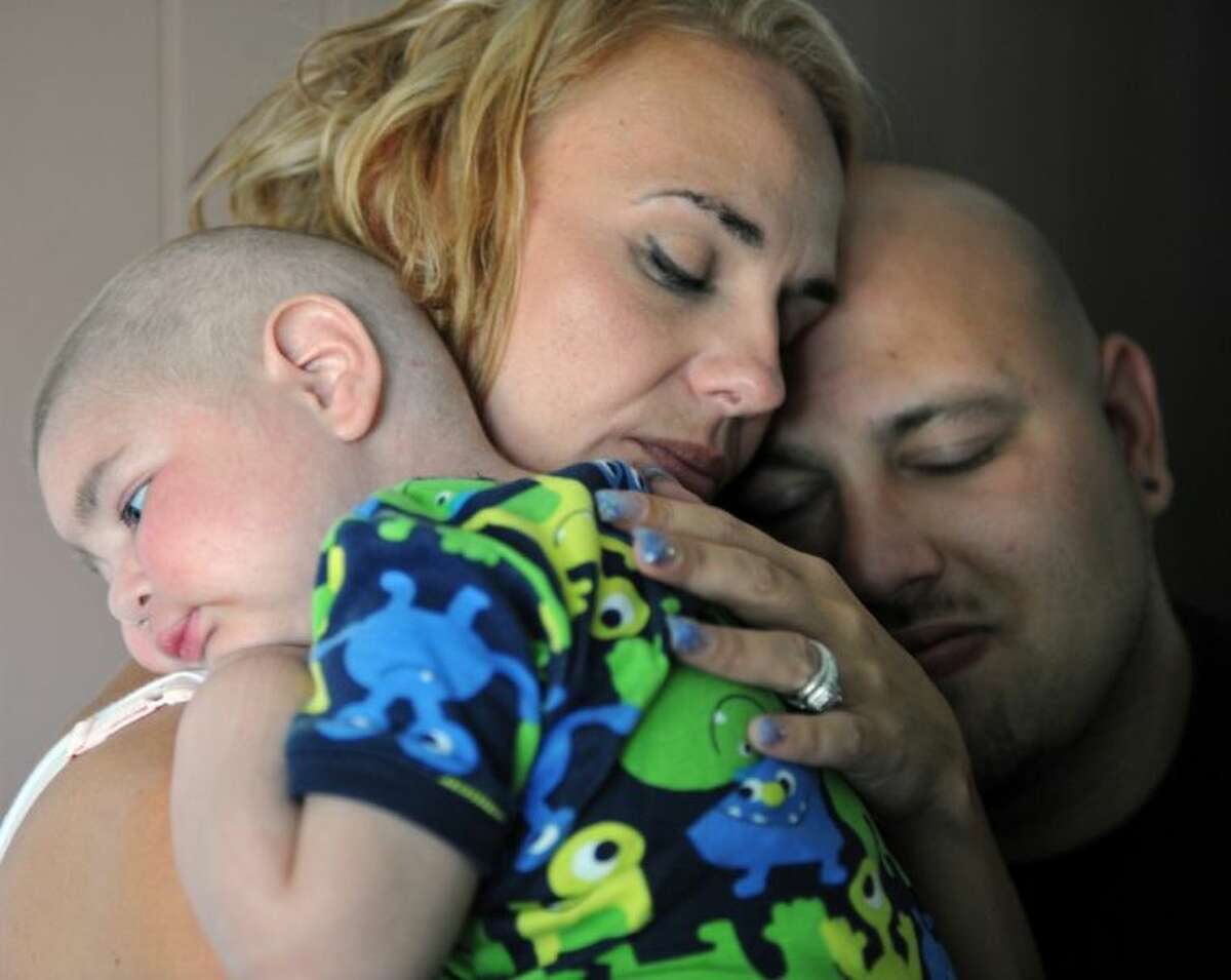 In this July 30 photo, Christine Swidorsky holds her son, Logan Stevenson, 2, with her husband-to-be and Logan’s father Sean Stevenson, for a portrait in their Jeannette, Pa., home. Christine Swidorsky Stevenson said on her Facebook page that Logan died in her arms at 8:18 p.m. Monday at their home. The couple live in Jeannette, about 25 miles east of Pittsburgh, and were wed at a ceremony at their home last Saturday. Logan, who had leukemia and other complications, served as his parents’ best man.