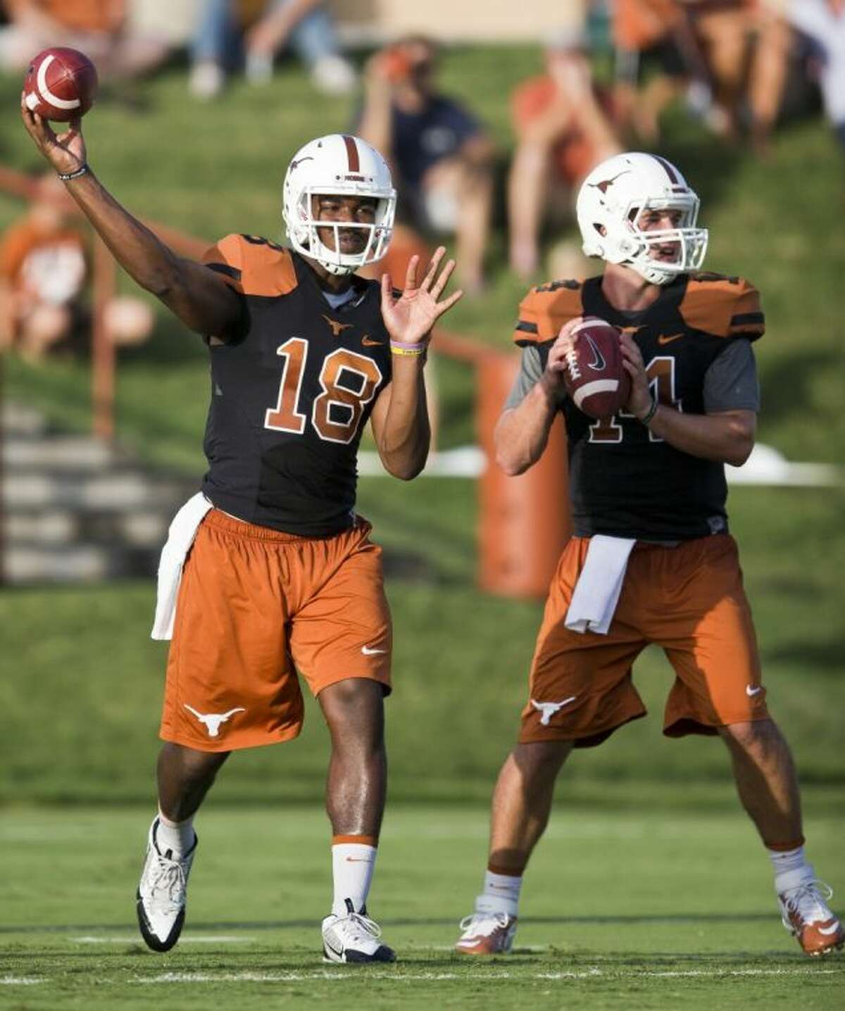 Texas quarterbacks Tyrone Swoopes, left, and David Ash throw during the first day of open practice on Aug. 8 at the Frank Denius Fields on the campus of the University of Texas at Austin.