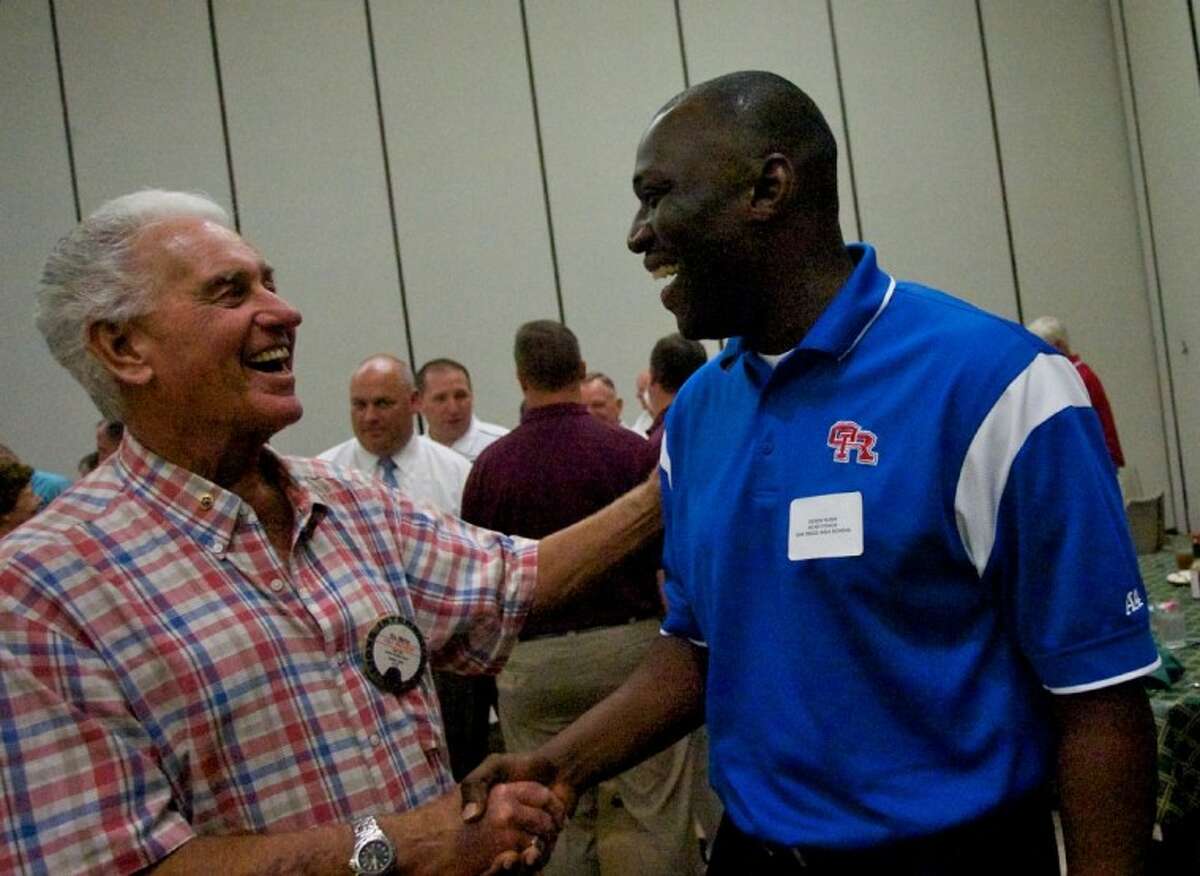 Oak Ridge coach Dereck Rush, right, chats with Conroe Noon Lions Club member Roy Morton during the 37th annual Buddy Moorhead District 14-5A Pigskin Preview on Wednesday at the Lone Star Convention and Expo Center.