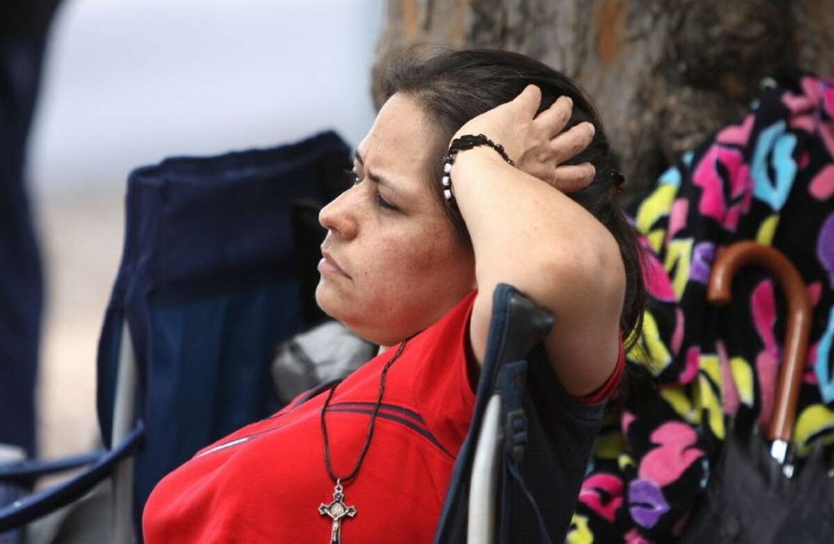 Gloria Martinez waits with her family for a chance to get in and file paperwork for President Obama’s Deferred Action immigration program outside the Mexican Consulate office in Houston Wednesday. Martinez had been waiting outside the consulate since 4:30 a.m., she said.