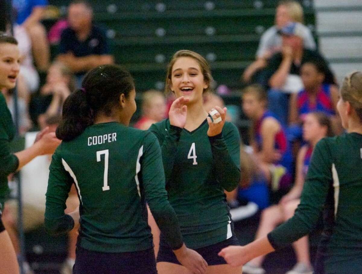 The John Cooper School’s Christina Gooch celebrates a point with teammates during Wednesday night’s season-opener against Lutheran North in The Woodlands.