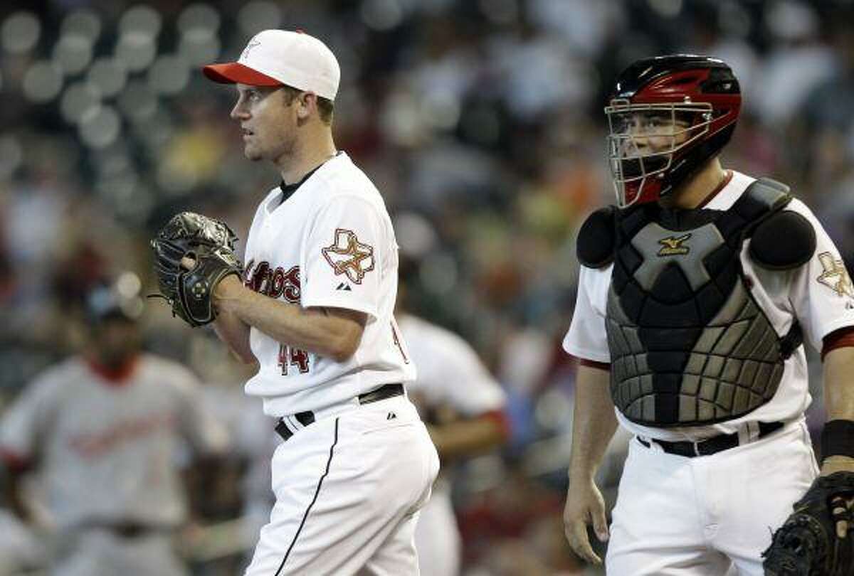 Houston Astros pitcher Roy Oswalt walks back to the mound with catcher Humberto Quintero during the third inning Monday in Houston.