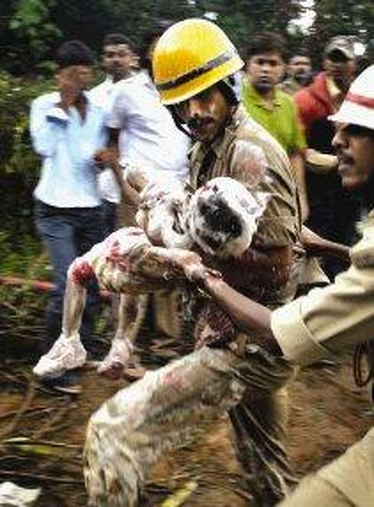 Indian firefighters carry a child, reportedly a survivor, out of the debris of an Air India plane that crashed in Mangalore, in the southern Indian state of Karnataka. The plane arriving from Dubai crashed Saturday morning after it overshot a runway while trying to land in southern India, and officials feared as many as 160 people on board were killed.