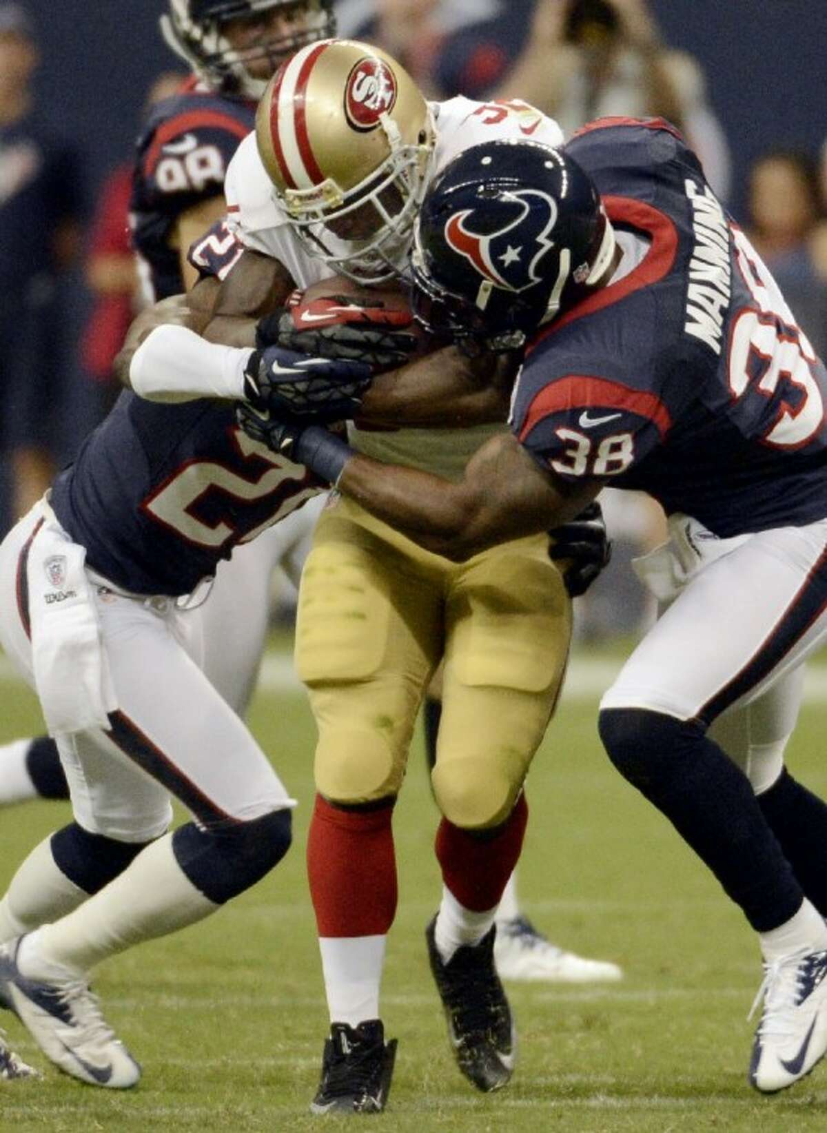 San Francisco’s Kendall Hunter is held up by Houston Texans Danieal Manning and Brice McCain. The Texans won 20-9.