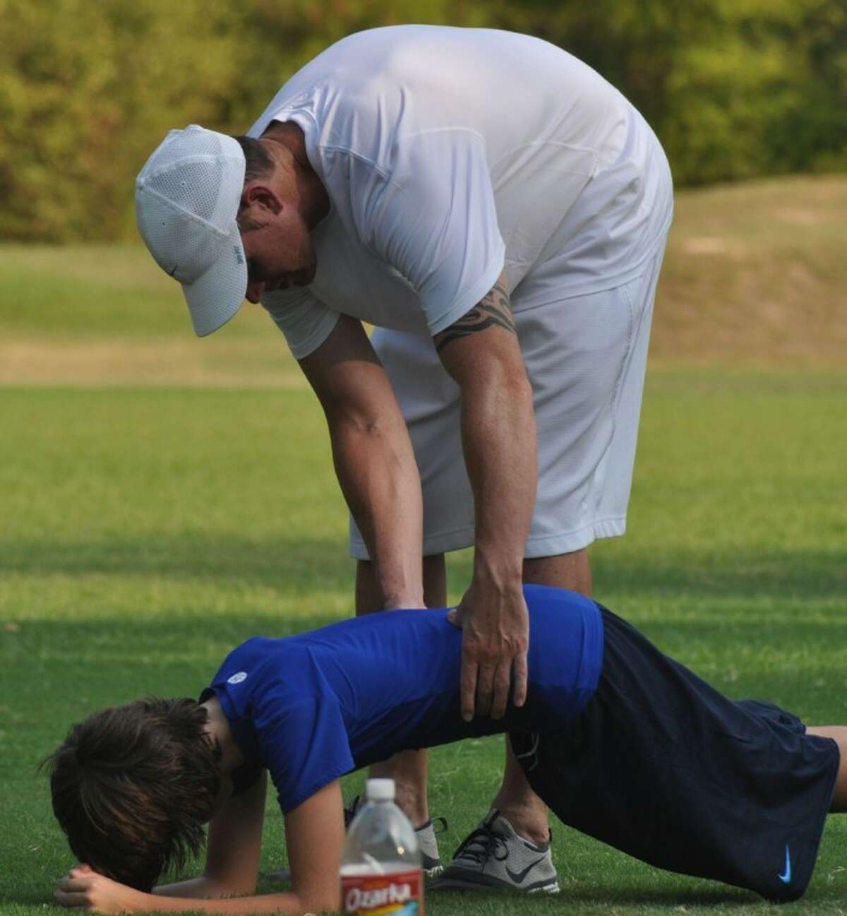 Jared Zabransky help Jacob Satterfield strengthen his core during one of his workouts on Monday in The Woodlands.