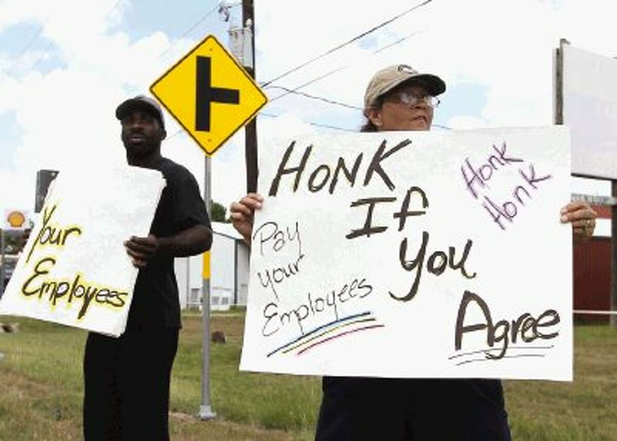 Mary Canny pickets along with Jonathan Anderson as employees protest Alders Farm on North Loop 336 E Thursday. According to the protesters, they have not been paid and demand payment from owner Mike Alders.