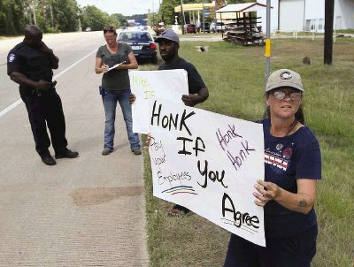 Mary Canny holds up a sign as she and other employees protest Alders Farm on North Loop 336 E Thursday. According to the protesters, they have not been paid and demand payment from owner Mike Alders.