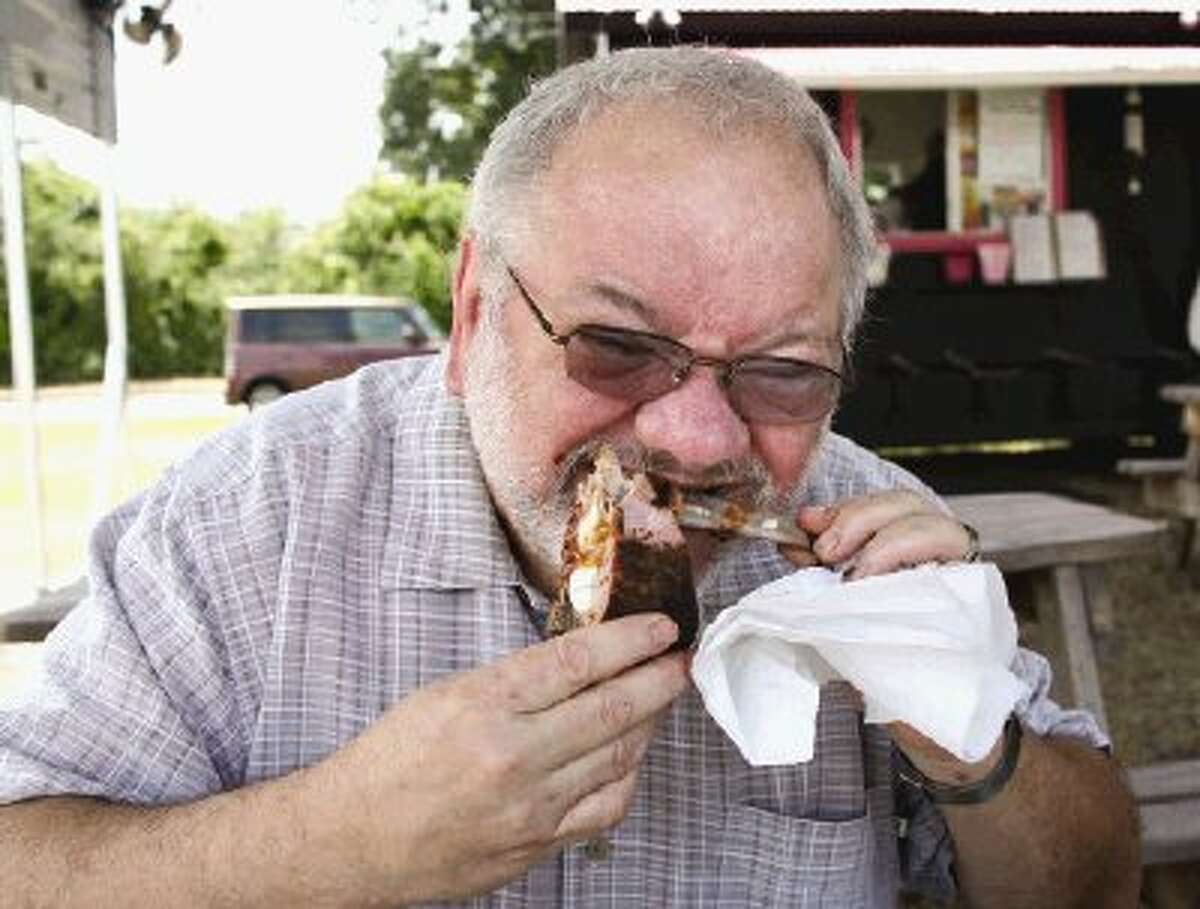 Mark Hayter gets sauce all over himself, the table and those around him while gnawing on a meaty pork rib.