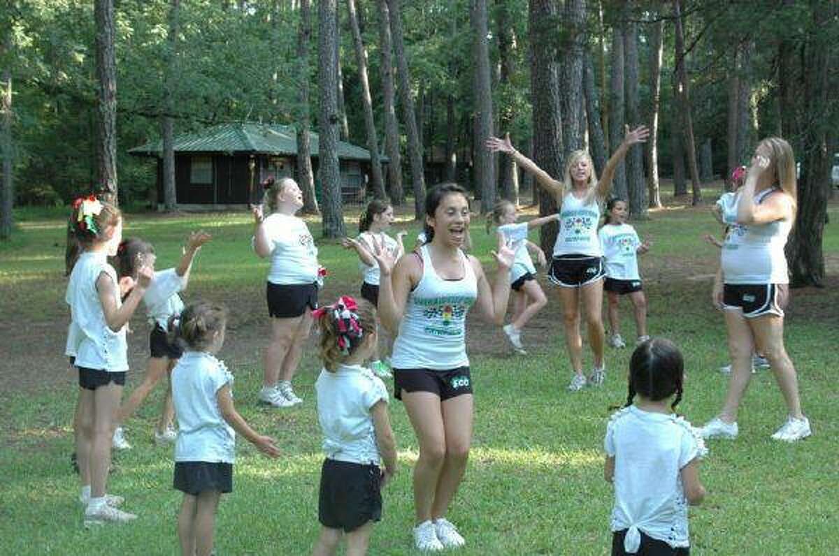 Emerald City Cheer staff members Jordan League (front) and Alissa Munch lead campers at the pep rally of a recent camp. This is Emerald City Cheer’s third year of Summer cheer camps near Willis. The second session will be next week. Hours of the camp are 9 a.m. to 3:30 p.m. Monday through Friday, with extended hours starting at 7:30 a.m. and lasting until 5:30 p.m. Sign-up is available through Monday. The camp offers training in tumbling, stunts/jumps, dance and cheer. Campers get to cool off in the pool once a day. To register for camp, call Ronny Burns at 936-228-2419.Right: Emerald City Cheer campers follow staff members’ lead during the pep rally, including Xander Burns (boys allowed) with his cousins Kylie Furstenfeld (right of him) and Alona Furstenfeld (left of him).