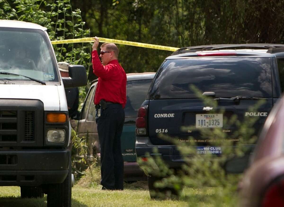 Conroe police investigators examine the scene where skeletal remains were found Tuesday on Criminal Justice Drive in Conroe.