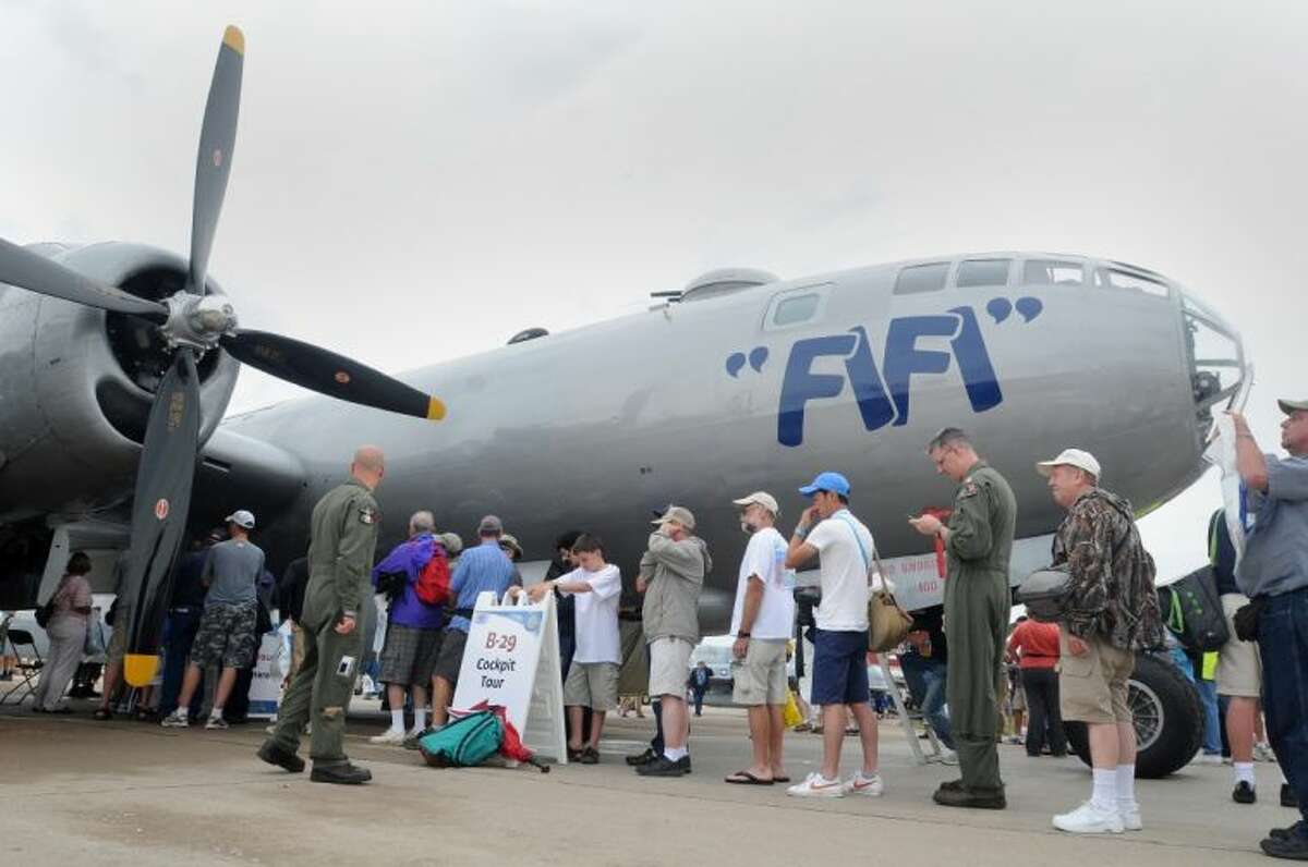 In this July 27, 2011, file photo, people stand in line for a tour of the cockpit aboard "Fifi," a Boeing B-29 aircraft, at the Experimental Aircraft Association's AirVenture in Oshkosh, Wis. One of the nation’s largest air shows begins Monday, July 29, 2013, in Wisconsin, and for each of the 10,000 planes flying in, the federal government will collect about 45 for air traffic control services. The fee has angered pilots, who already pay for air traffic control through a fuel tax.