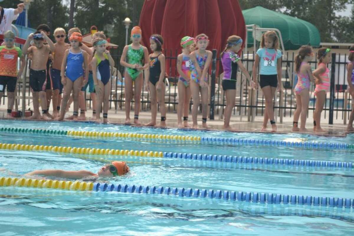 Lucas Menendez, 7, of The Woodlands is one of the first to begin the race by swimming 50M in the pool during the 2013 Kiwanis Kids YMCA Triathlon Saturday morning at the South Montgomery County YMCA.