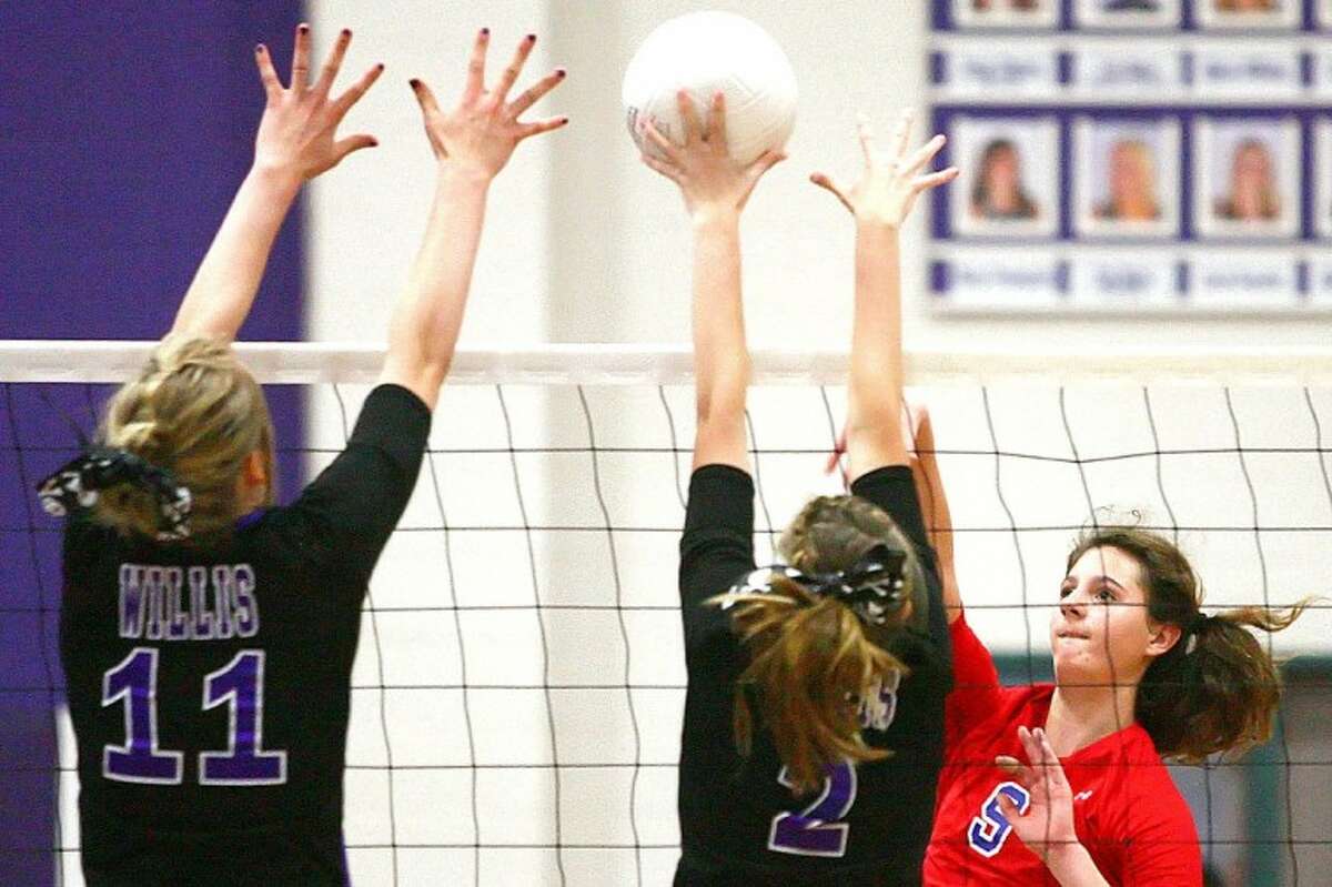 Oak Ridge’s Nikki Testerman goes for a kill as Willis’ Hope Pawlik and Tessa Hudzietz go up for a block during the match Tuesday at Willis High School.
