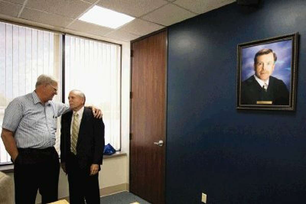 Former Montgomery County Court-at-Law 2 Judge Jerry Winfree, right, speaks with a friend as his newly unveiled portrait hangs on a nearby wall Wednesday.