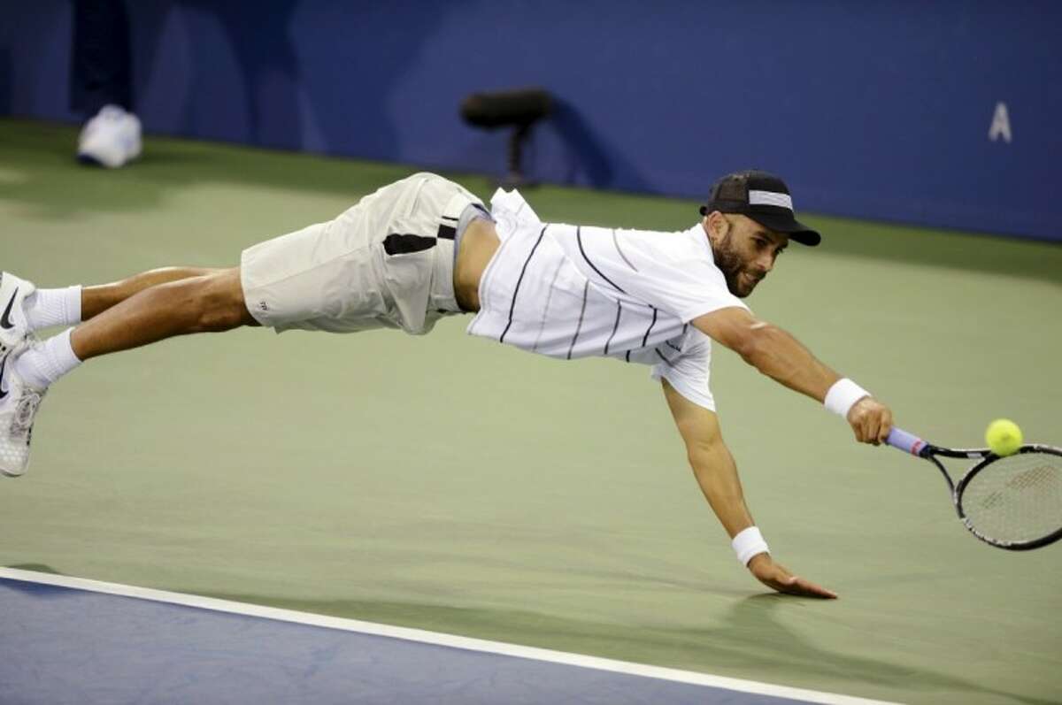 James Blake reaches for a shot from Milos Raonic, of Canada, in the third round of the U.S. Open.