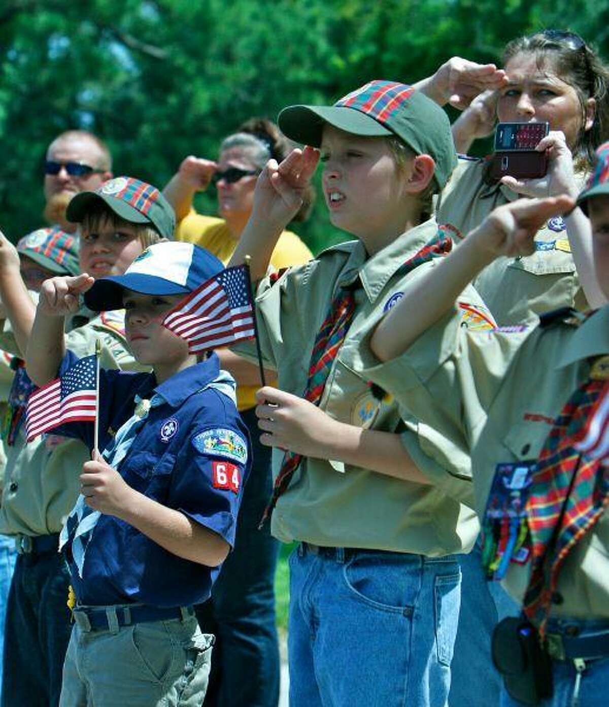 Boy Scouts from Troop 64 and Pack 64 salute the motorcade carrying the body of Army Staff Sgt. Jessie Ainsworth as it makes its way to Pace Stancil Funderal Home on Texas 321 in Dayton Friday.