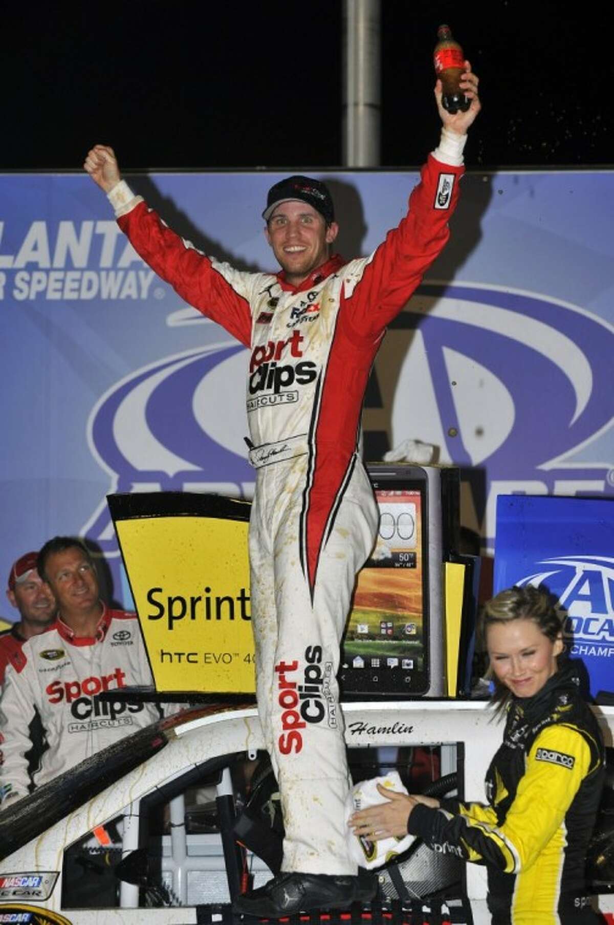Denny Hamlin celebrates in Victory Lane after winning the NASCAR Sprint Cup Series auto race at Atlanta Motor Speedway.