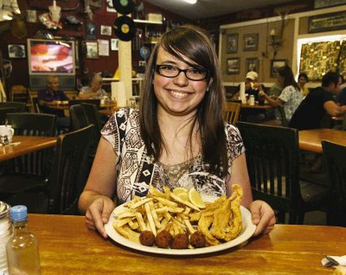 Courier summer intern, Candice Nichols, 16, displays a large platter of fried catfish and a double order of fries -- which she finished at the Fish Pond.