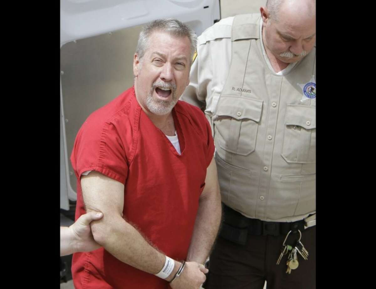 In this May 8, 2009 file photo, former Bolingbrook, Ill., police sergeant Drew Peterson yells to reporters as he arrives at the Will County Courthouse in Joliet, Ill., for his arraignment on charges of first-degree murder in the 2004 death of his former wife Kathleen Savio. A jury on Thursday found Peterson guilty of murdering his third wife.