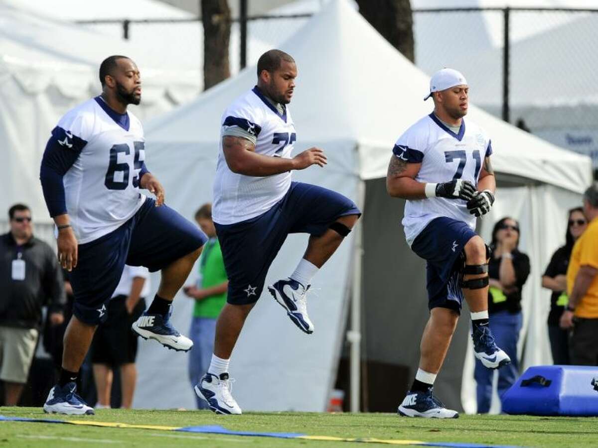 From left, Dallas Cowboys guards Ronald Leary, Mackenzy Bernadeau and Nate Livings warm up during training camp on July 24 in Oxnard, Calif.