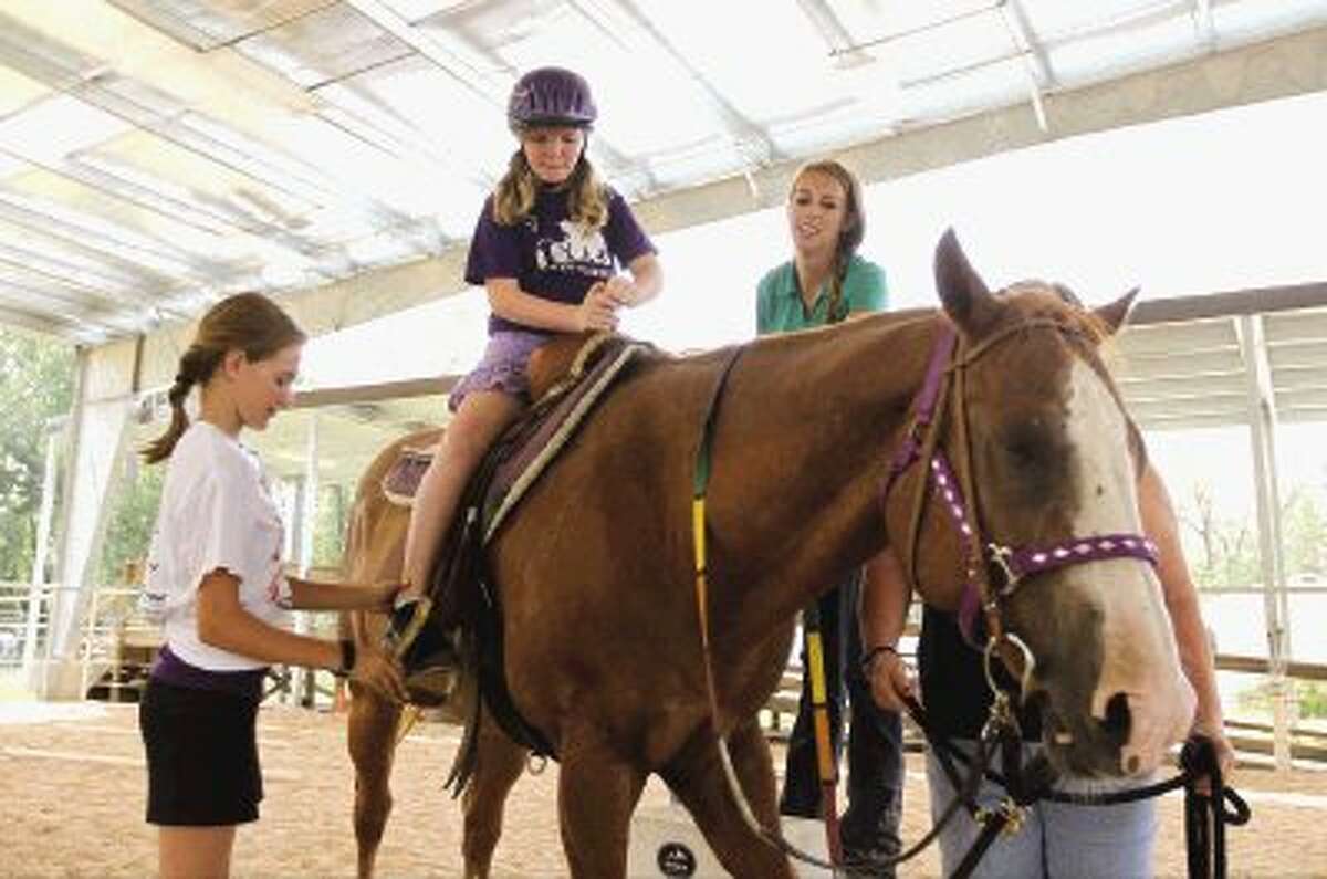 Volunteers work in heat, groom horses, helping special needs kids