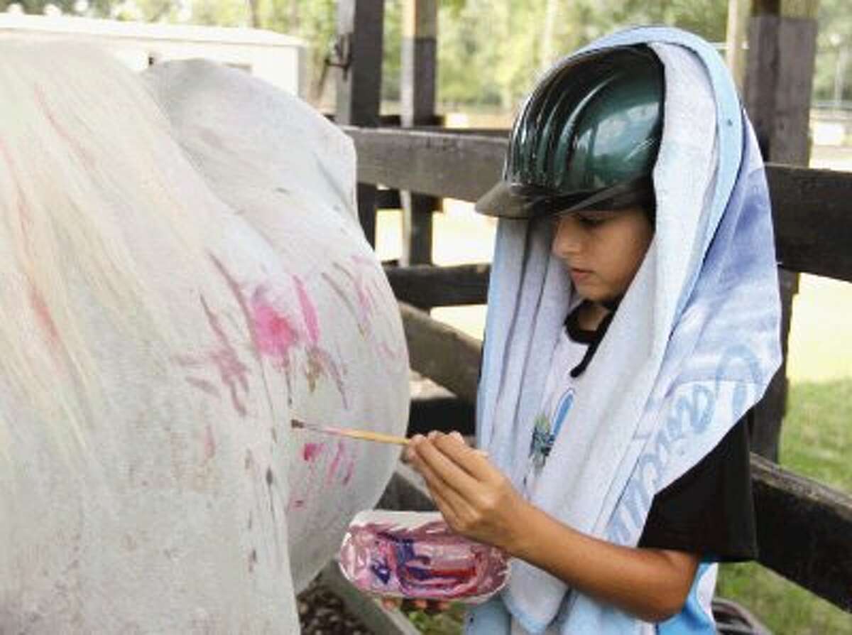 Evan Sarraf paints a horse during a horse therapy session at the Conroe YMCA Thursday. The therapy helps children with special needs work on social, physical and emotional skills. Go to HCNPics.com to view and purchase this photo and others like it.