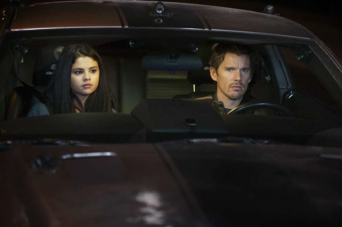 This film image released by Warner Bros. Pictures shows Selena Gomez, left, and Ethan Hawke in a scene from “Getaway.”