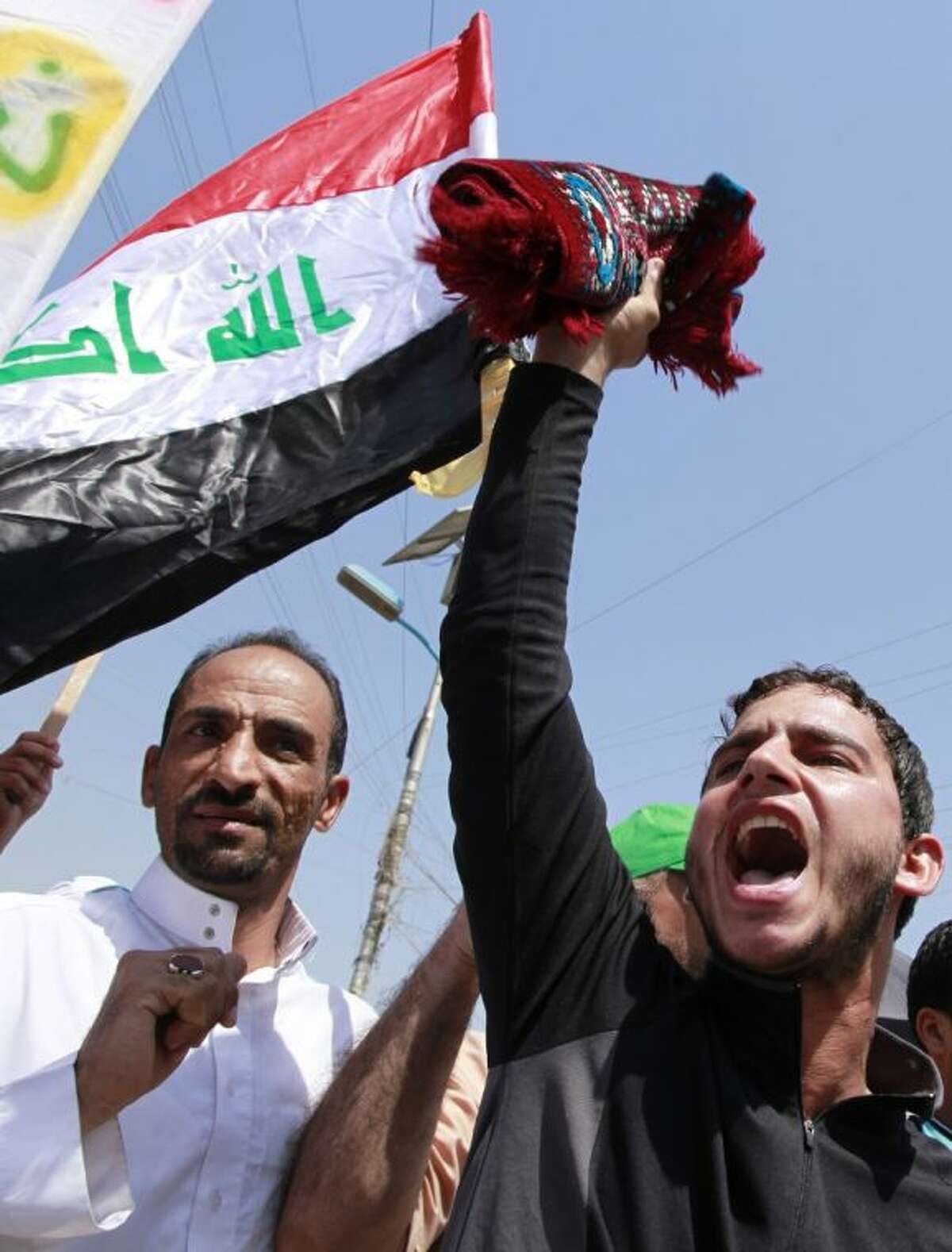 Followers of Shiite cleric Muqtada al-Sadr chant slogans against the U.S. and wave Iraqi and Syrian flags during a demonstration in Sadr City in Baghdad, Iraq, Friday. Followers of Shiite cleric Muqtada al-Sadr held rallies in Baghdad and the southern Iraqi city of Basra to denounce any Western strikes against Syria.