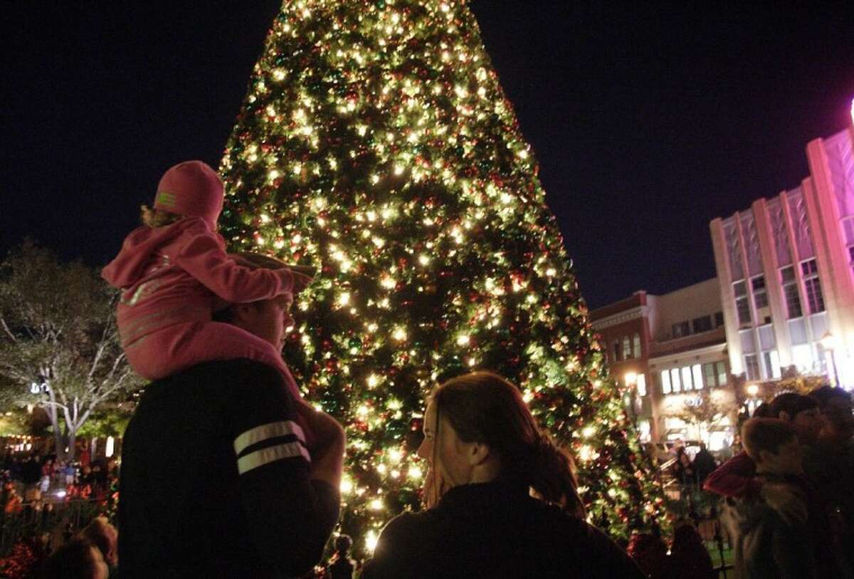 Mark Thomas holds up daughter Taylor, 2, for a better look at the Market Street Christmas Tree following Thursday night’s tree lighting ceremony in The Woodlands.